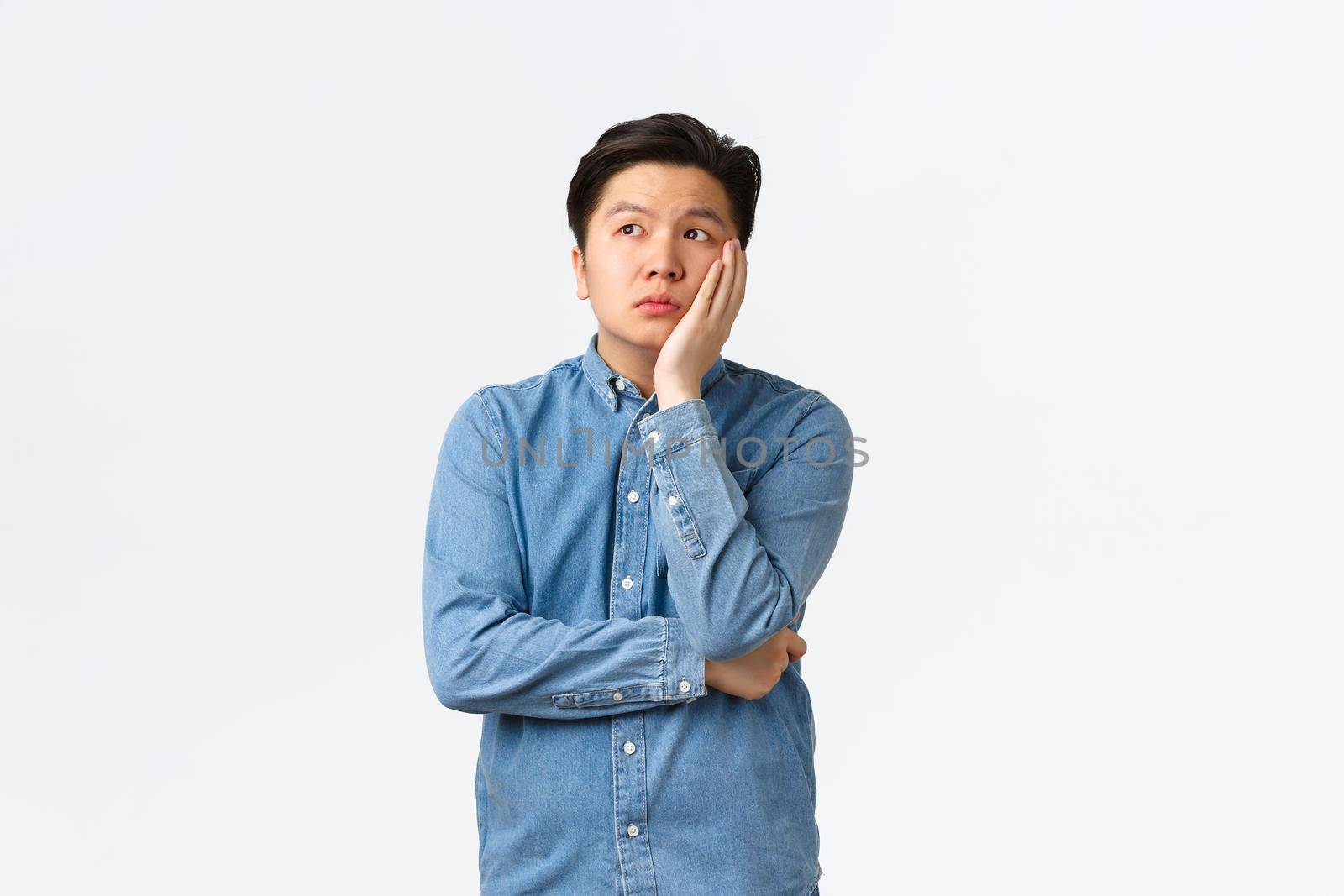 Bored and exhausted asian male student feeling unamused, space out at lecture, leaning face on hand and looking away dreamy, feeling boredom, standing white background, attend boring class by Benzoix