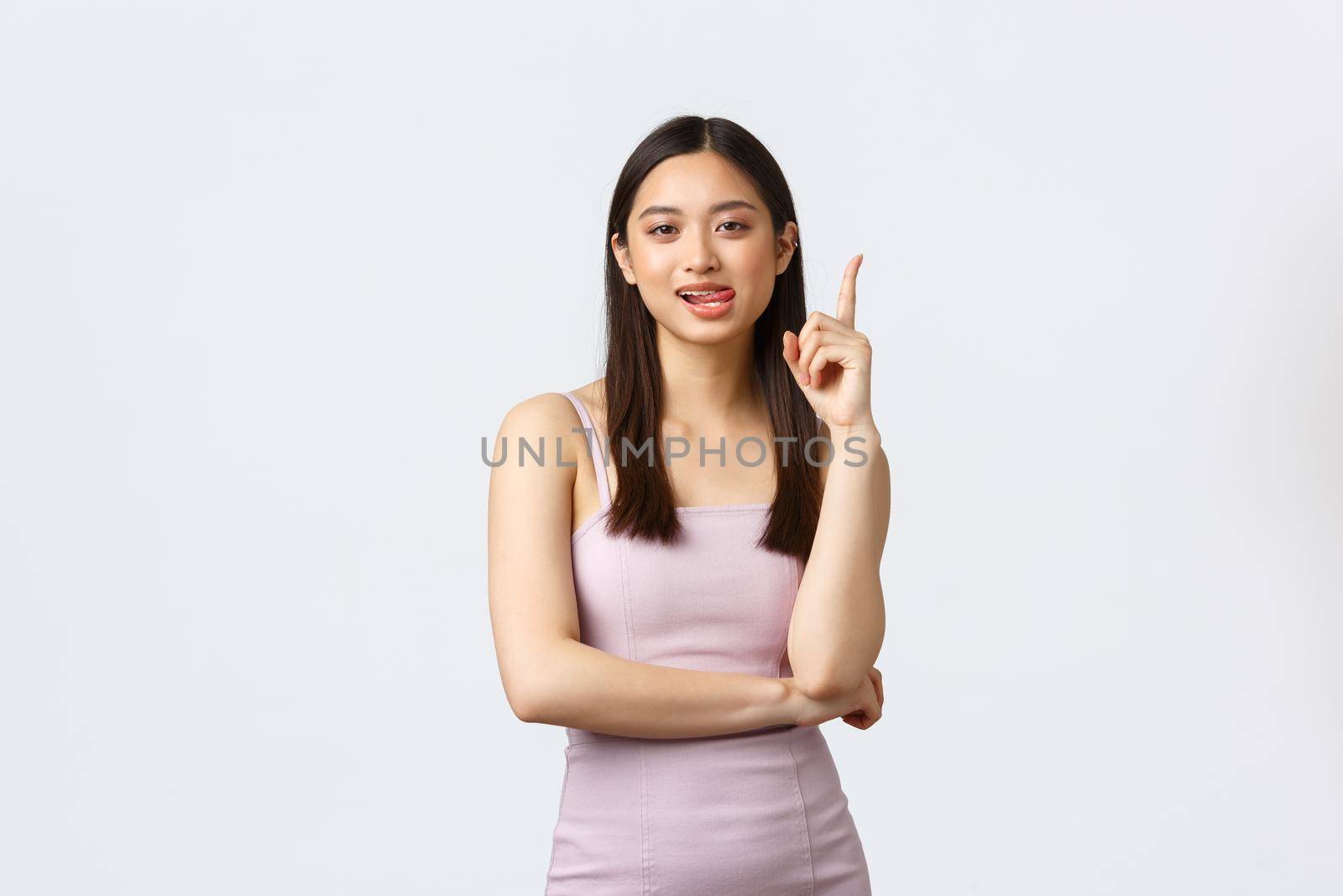 Luxury women, party and holidays concept. Creative attractive asian woman in evening dress have suggestion, raise index finger in eureka sign, propose solution or idea, white background.