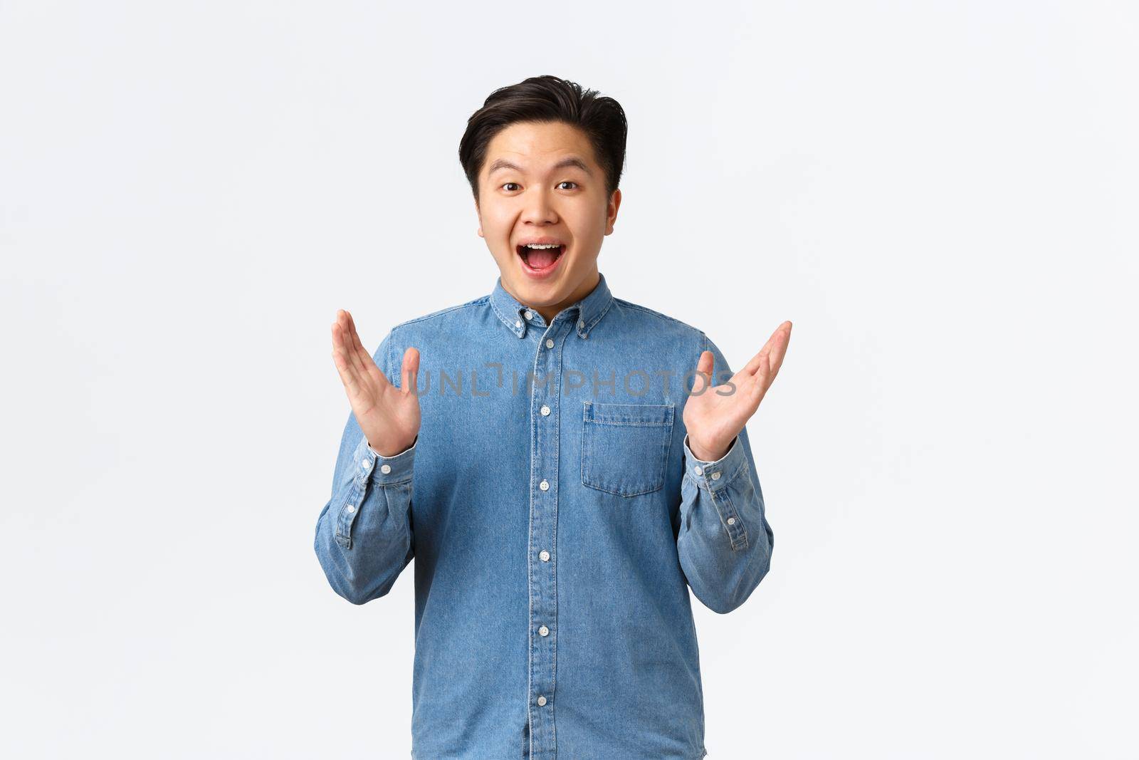 Happy proud and pleased asian male clap hands. Cheerful surprised guy applausing and congratulating with achievement, praising great work, saying well done to coworker, white background.