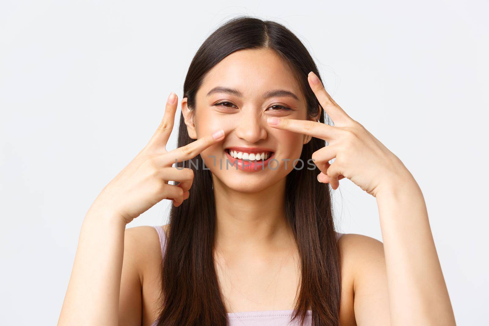 Concept of beauty, fashion and makeup products advertisement. Close-up portrait of carefree laughing, cute asian woman enjoying party, showing peace kawaii signs and smiling.