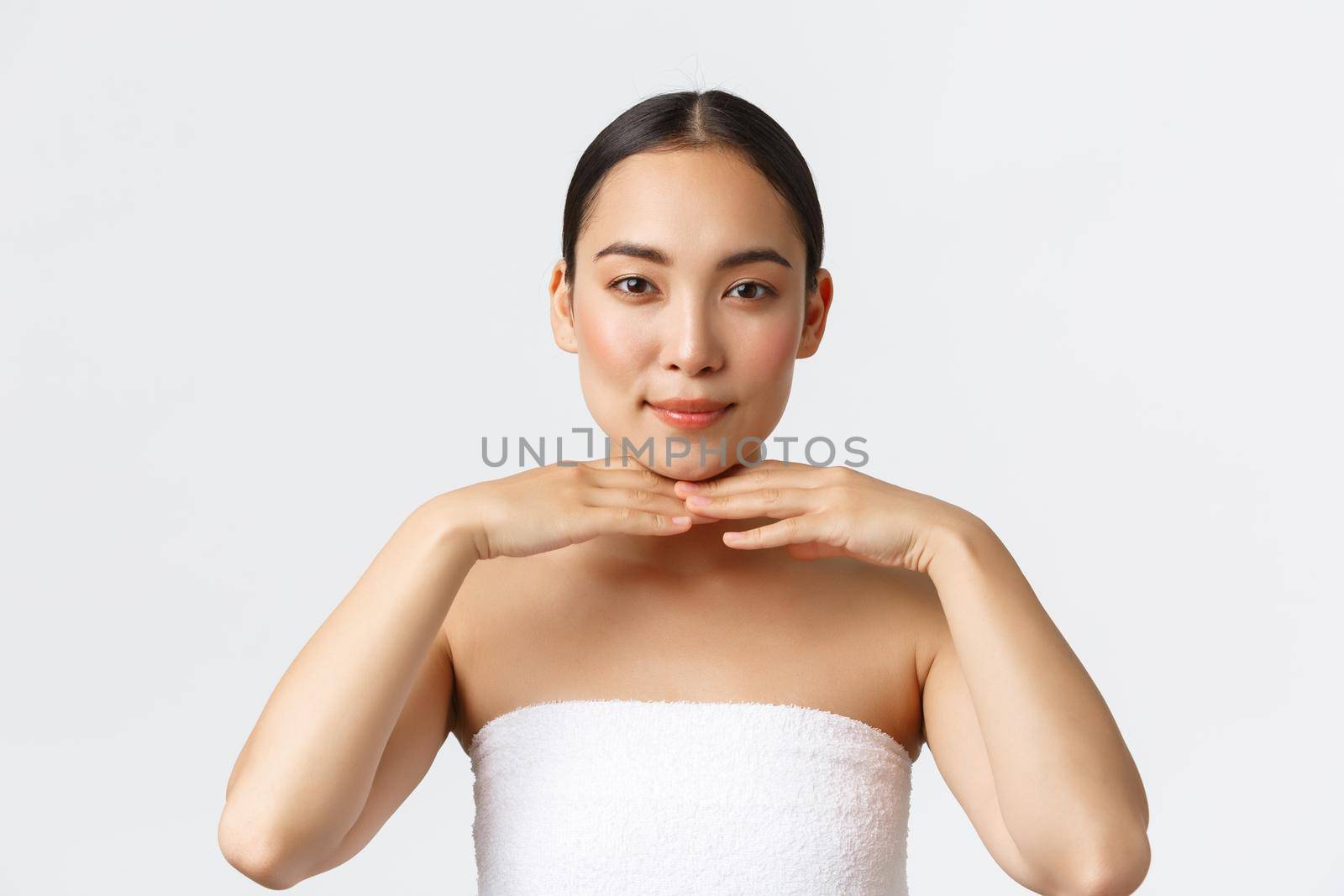 Beauty, cosmetology and spa salon concept. Beautiful and tender asian female client of beauty clinic wearing towel, touching jawline as showing clean perfect skin, advertise facial product by Benzoix