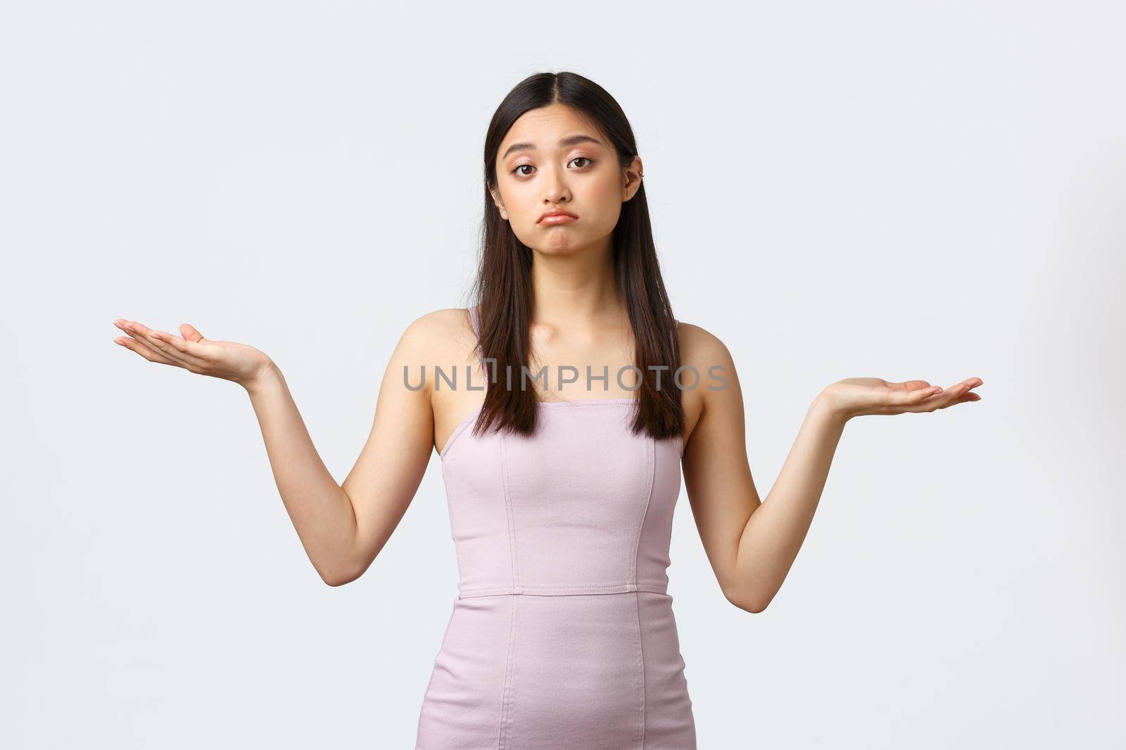 Luxury women, party and holidays concept. Clueless gloomy asian girl in evening dress, shrugging with hands spread sideways, dont know what product better, smirk unaware and doubtful by Benzoix