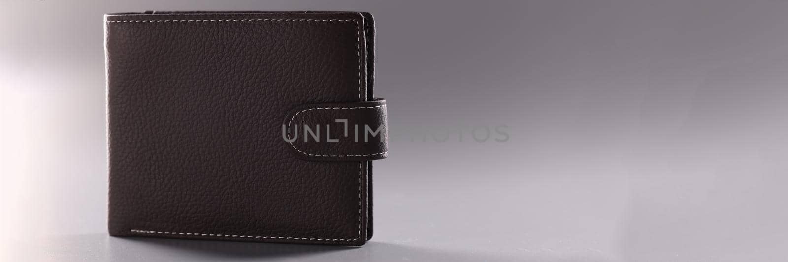 Brown leather closed wallet on gray background by kuprevich