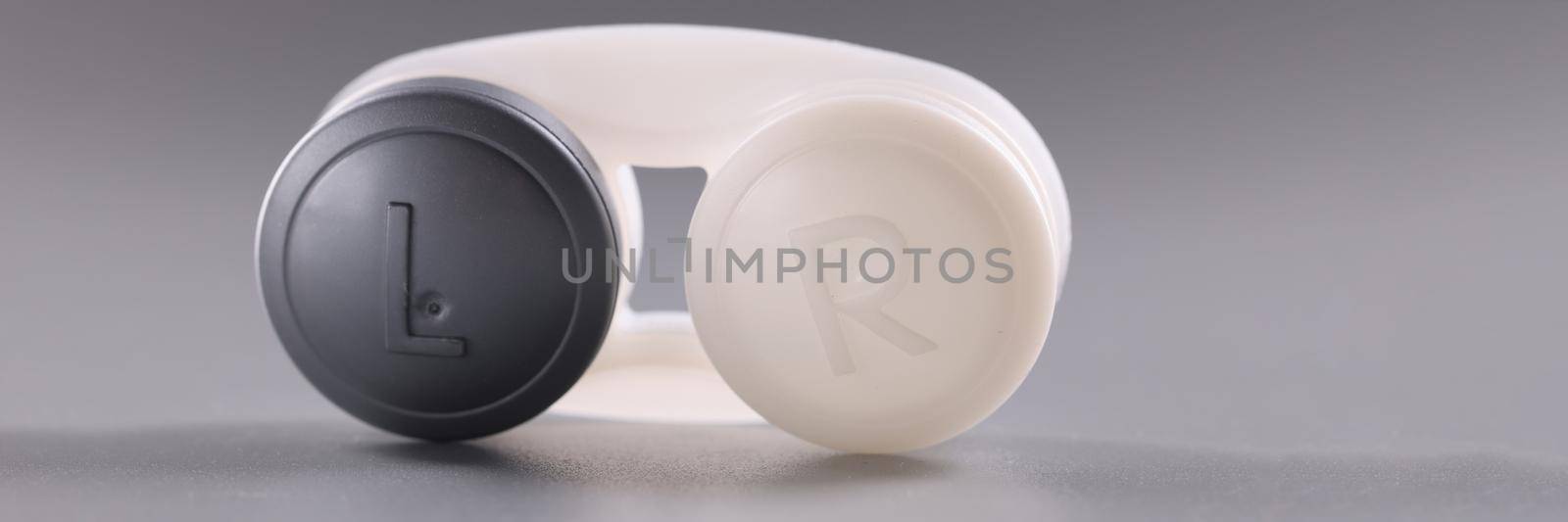 Container for contact lenses on gray background. Ophthalmology and medical concept