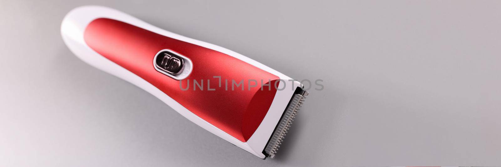 Electric razor for cutting hair on gray background. Home barber equipment and technology