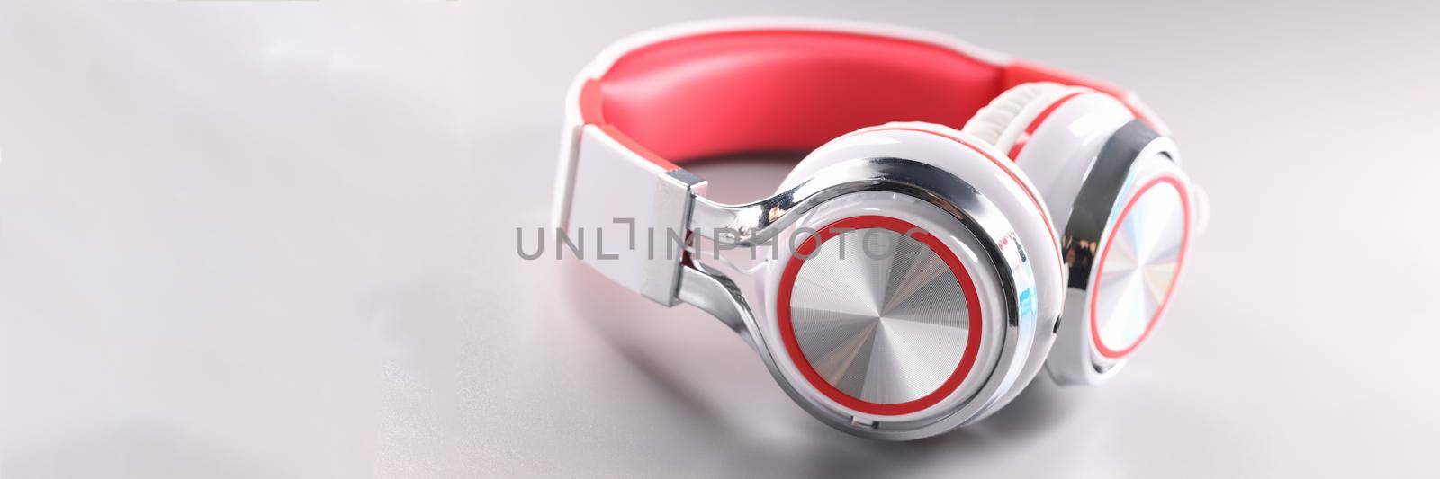 White red wireless headphones on gray background. Choosing headphones for listening to music concept