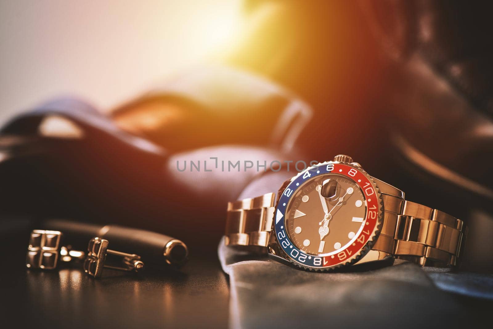 men's accessories, closeup at wristwatch with black dial blue-red bezel and stainless steel bracelet.