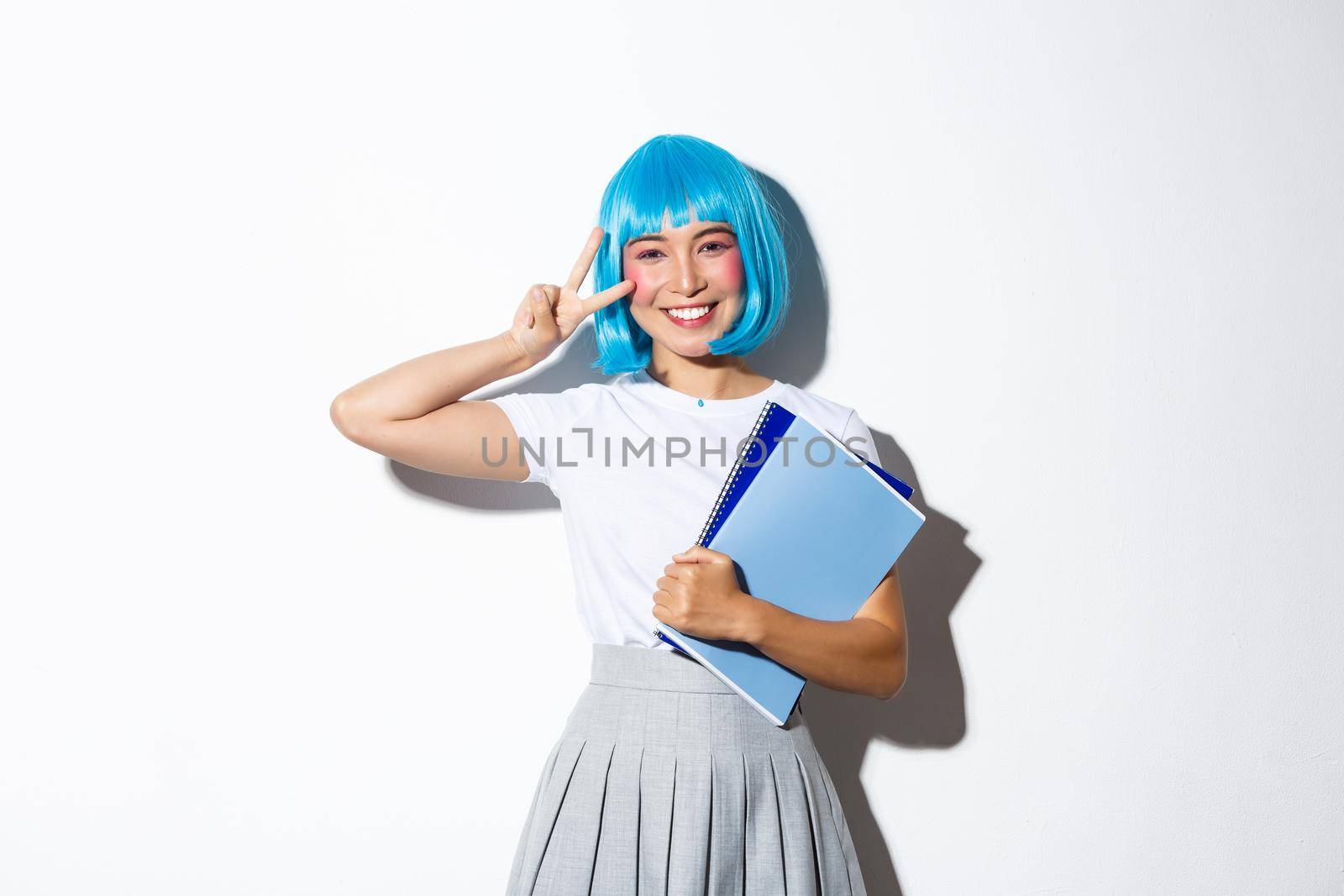Beautiful asian girl in blue anime wig, showing kawaii peace gesture, holding notebooks, wearing schoolgirl costume for halloween party by Benzoix