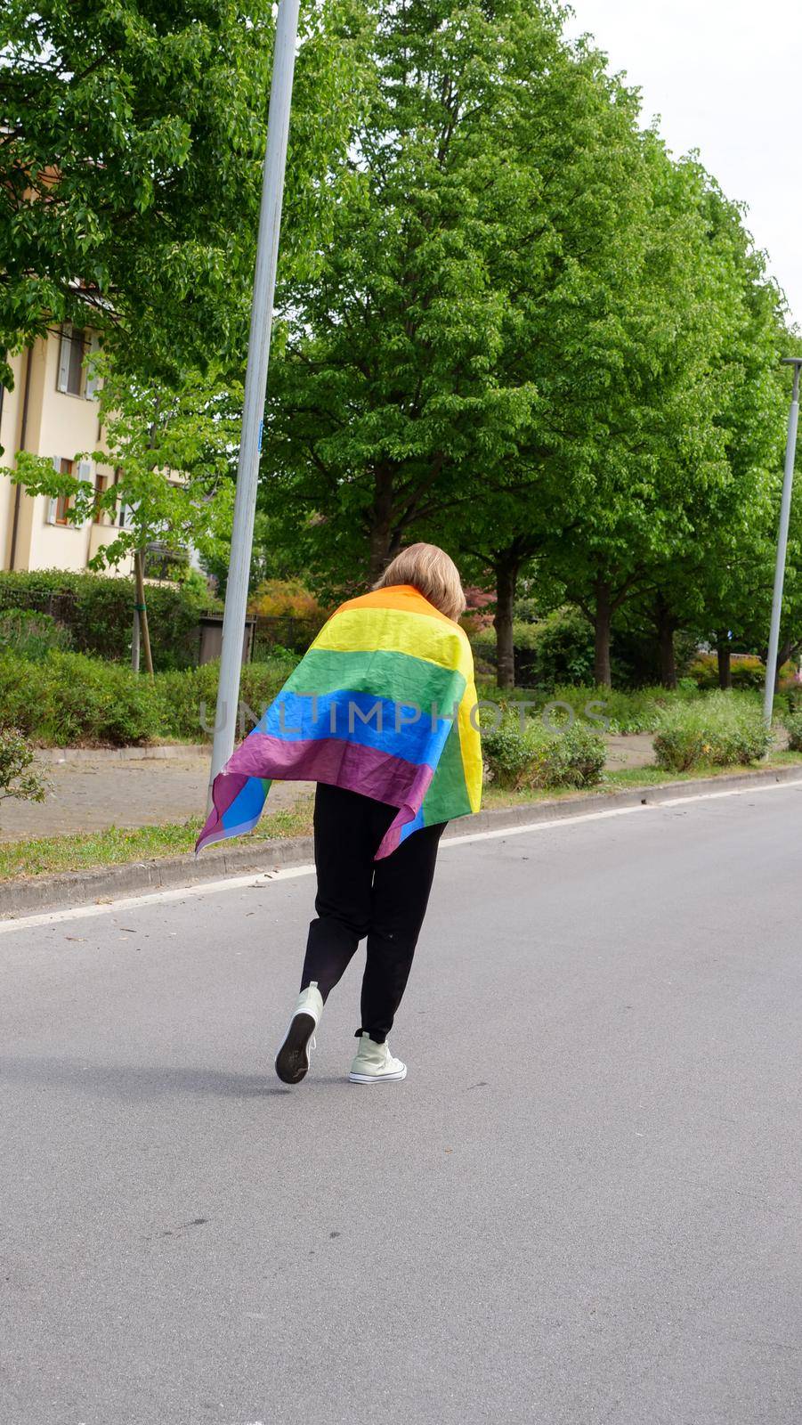 Bisexual, lesbian, woman, female, transgender walk back with LGBTQIA flag, rainbow peace in pride mounts on the road on a day and celebrate Bisexuality Day or National Coming Out Day