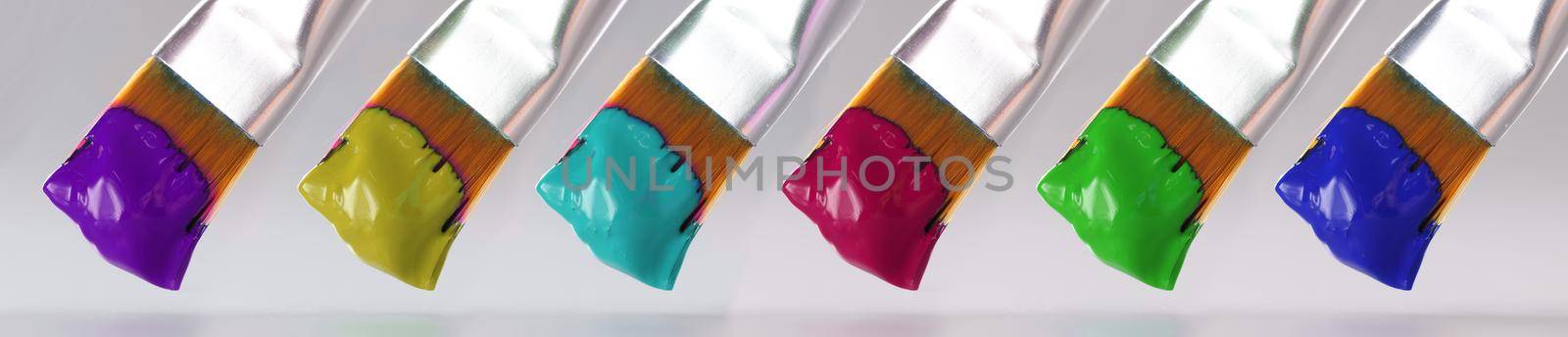 Three brushes with different paint colors closeup by kuprevich