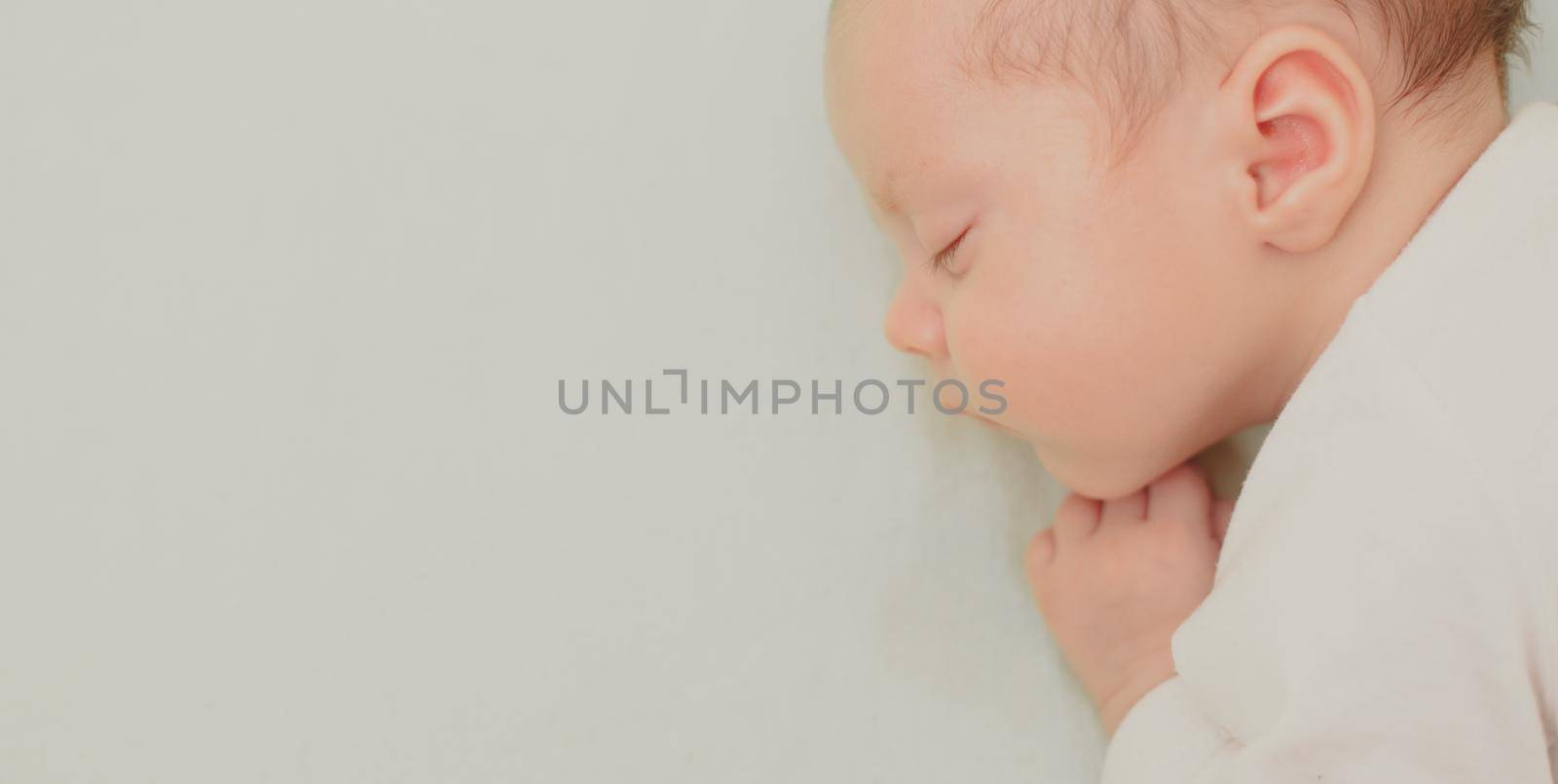 The baby sleeps in the copy space crib . Advertising of children's goods. Illustrating children's articles. A small child. A newborn. A child's dream.