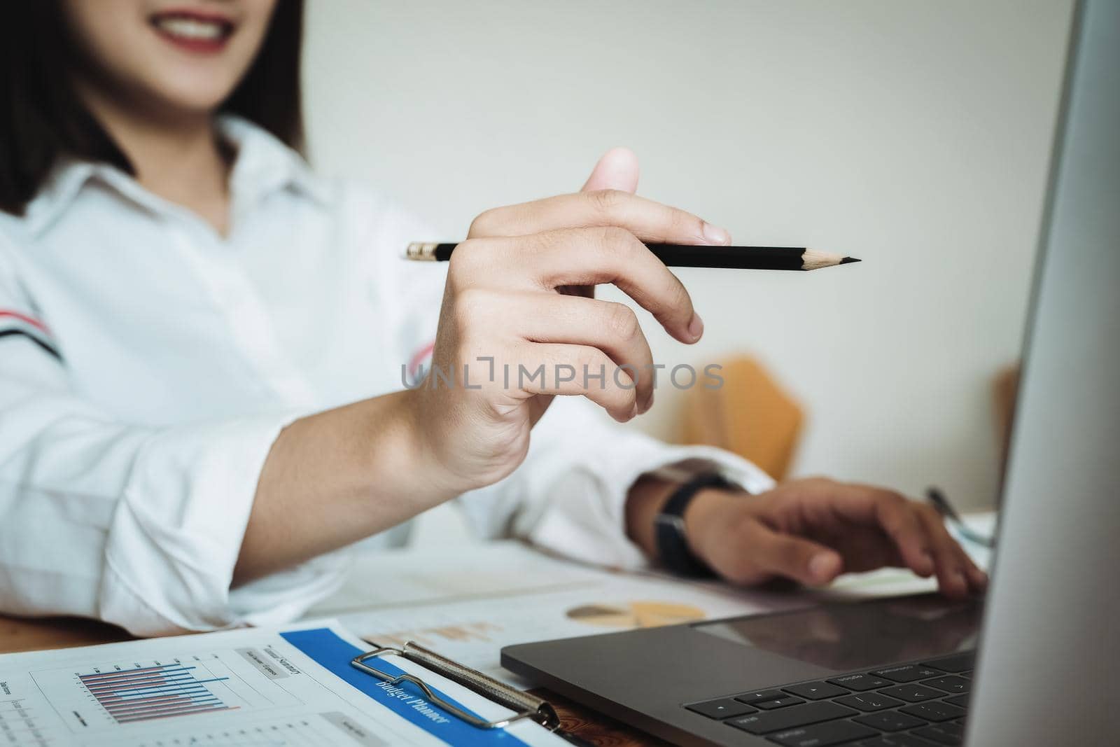 freelance concept, female hand holding pen point computers to design work as ordered by customers. by Manastrong