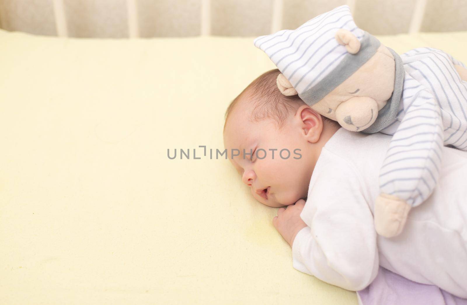 The baby sleeps in the copy space crib . Advertising of children's goods. Illustrating children's articles. A small child. A newborn. A child's dream.