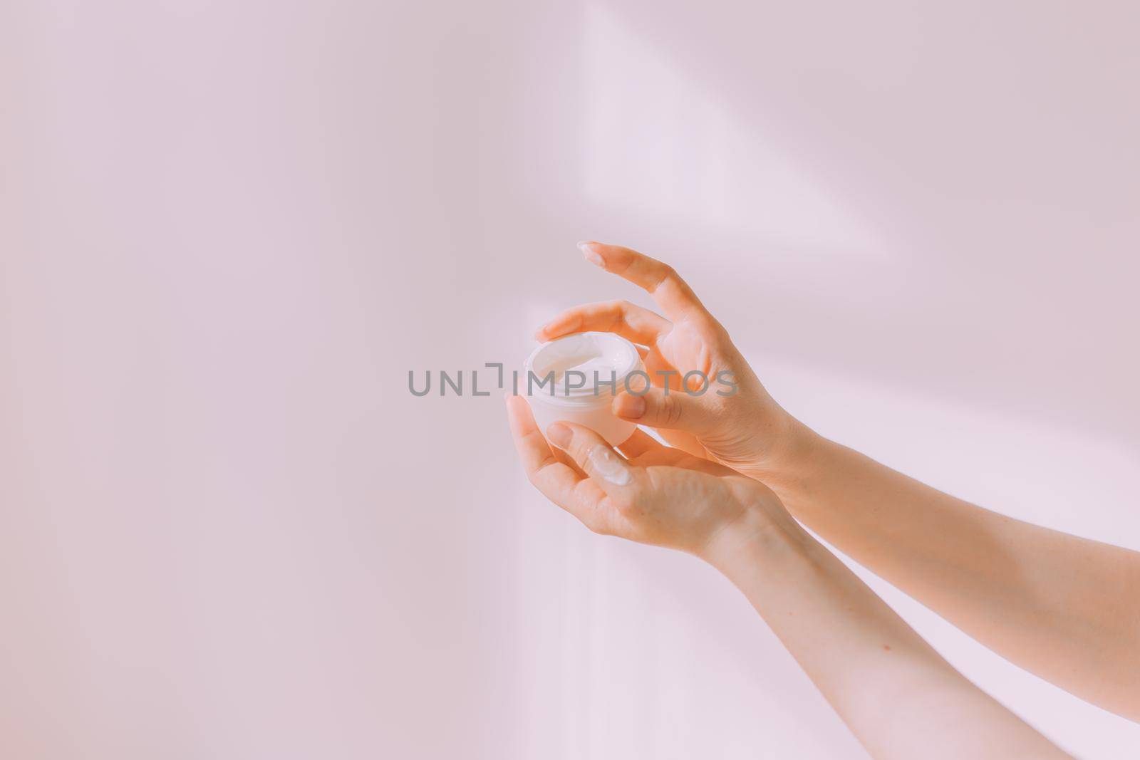 Women's hands hold a cosmetic copy space cream . An article about care cosmetics. Hand cream. Face cream.