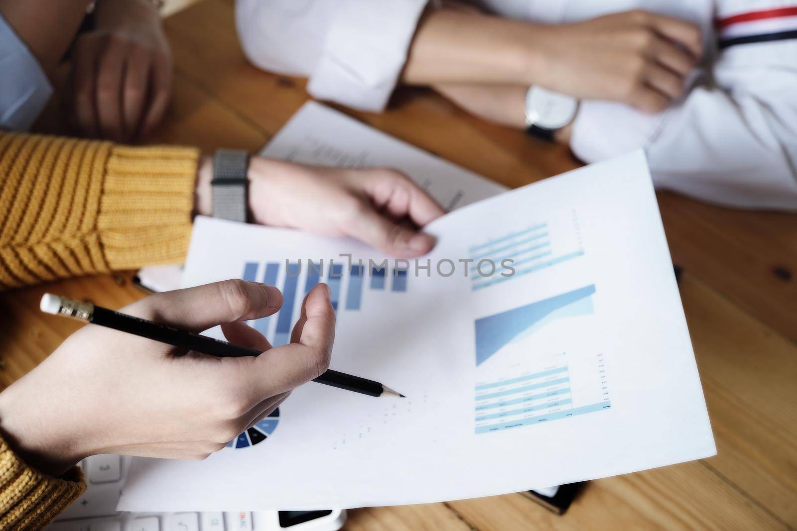 The auditor hand holding pen and budget graph document to examine the misuse of company funds