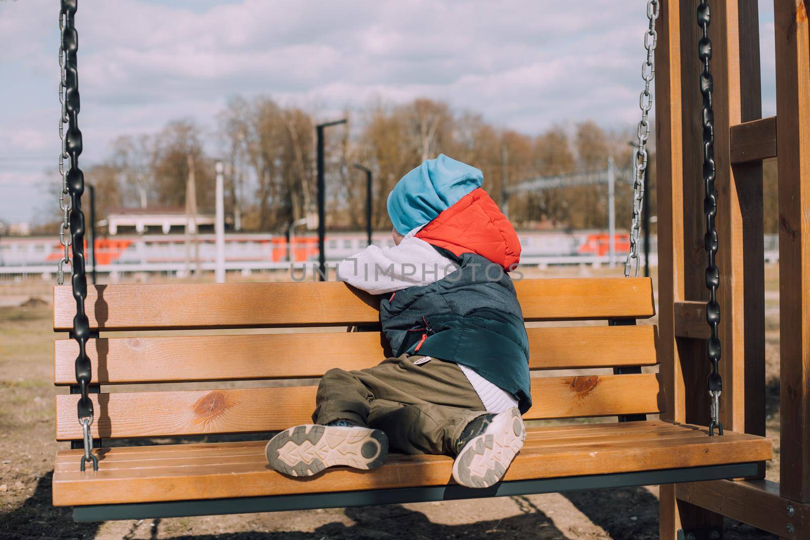 The offended boy is sitting on a lifestyle bench . Childish grievances. Childish anger. An article about children's emotions. An article about the psychology of children. by alenka2194