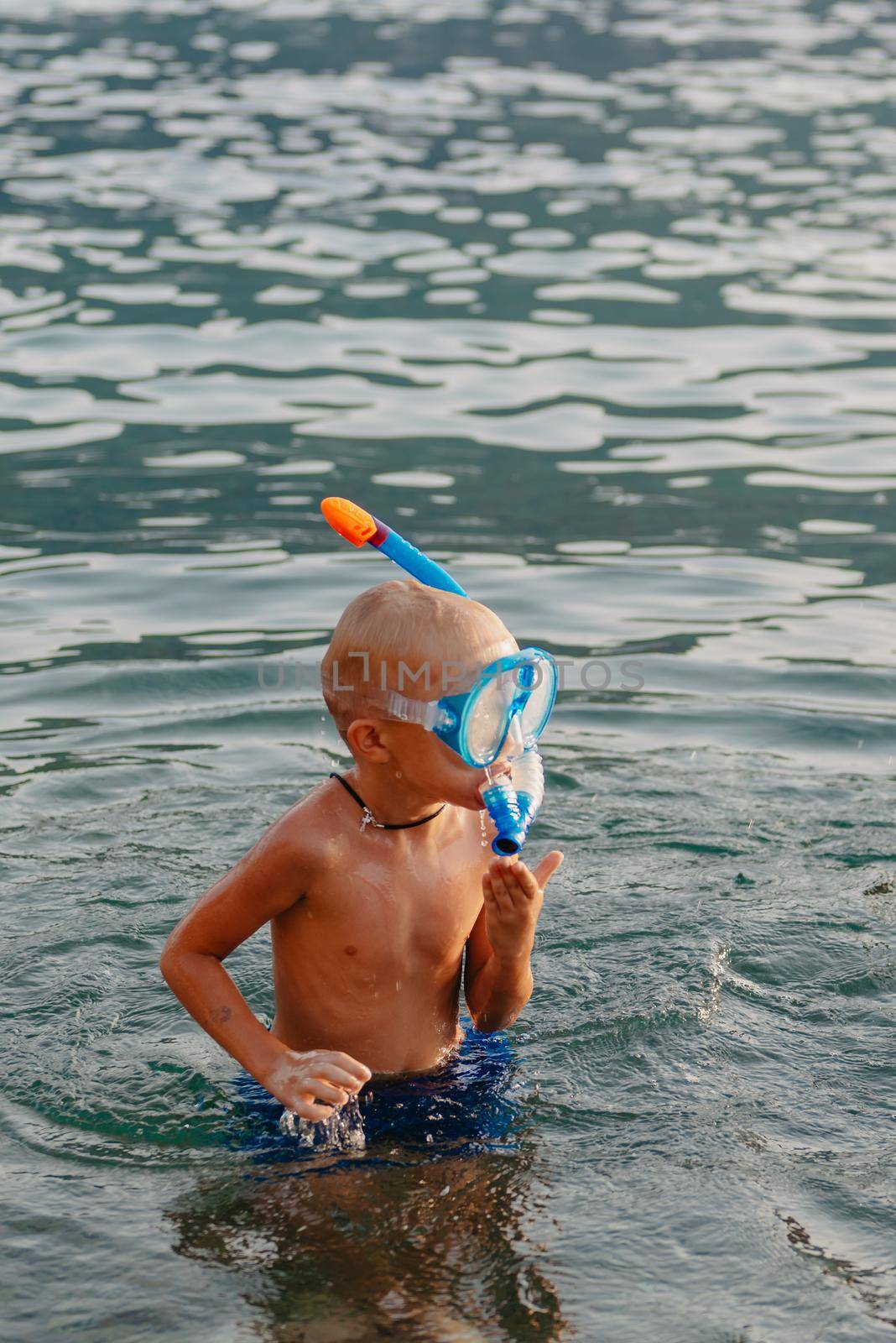 Cute happy little boy swimming and snorking in the sea. Child wearing snorkeling mask diving underwater, little boy enjoy swim underwater on tropical resort by Andrii_Ko