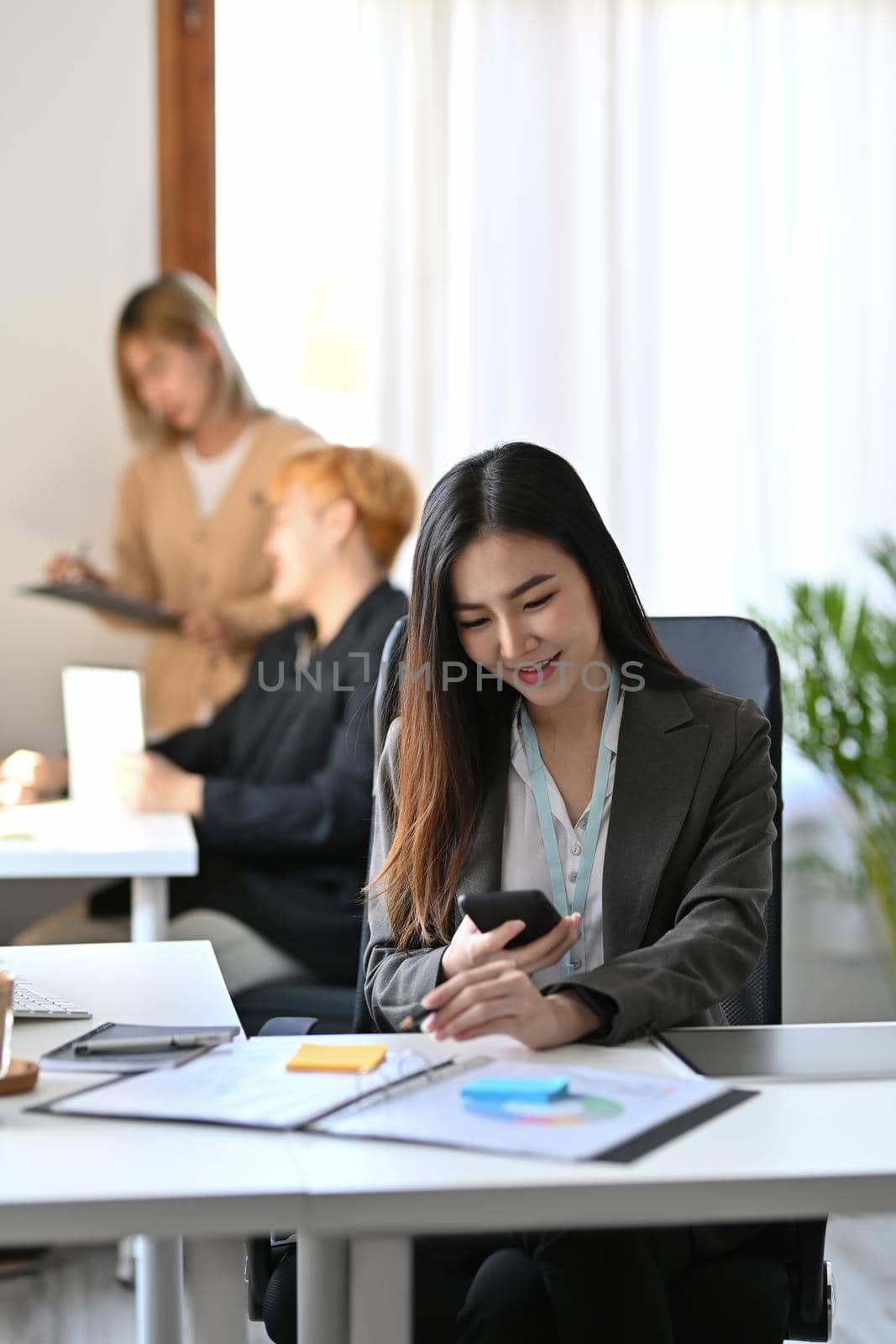 Asian businesswoman resting in office and using smart phone.