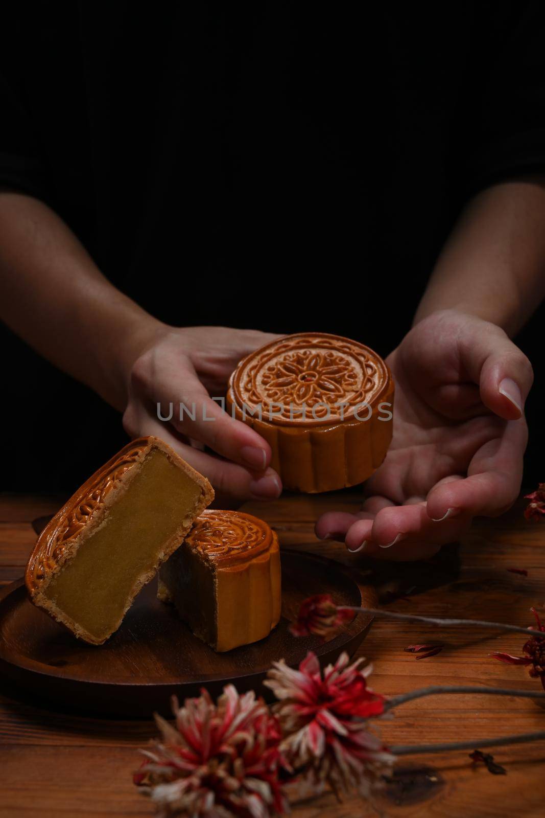 Close up view hands holding Chinese traditional mooncake. Mid Autumn festival and Chinese traditional festival concept.