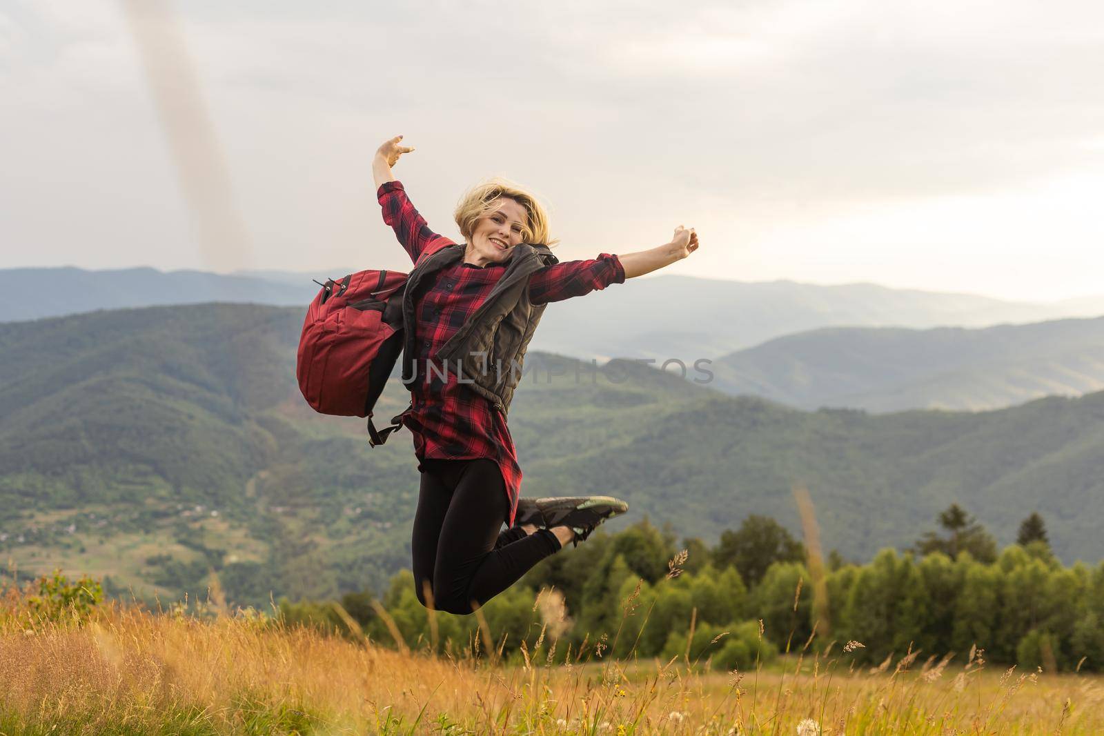 a woman rests after a hike in the mountains.