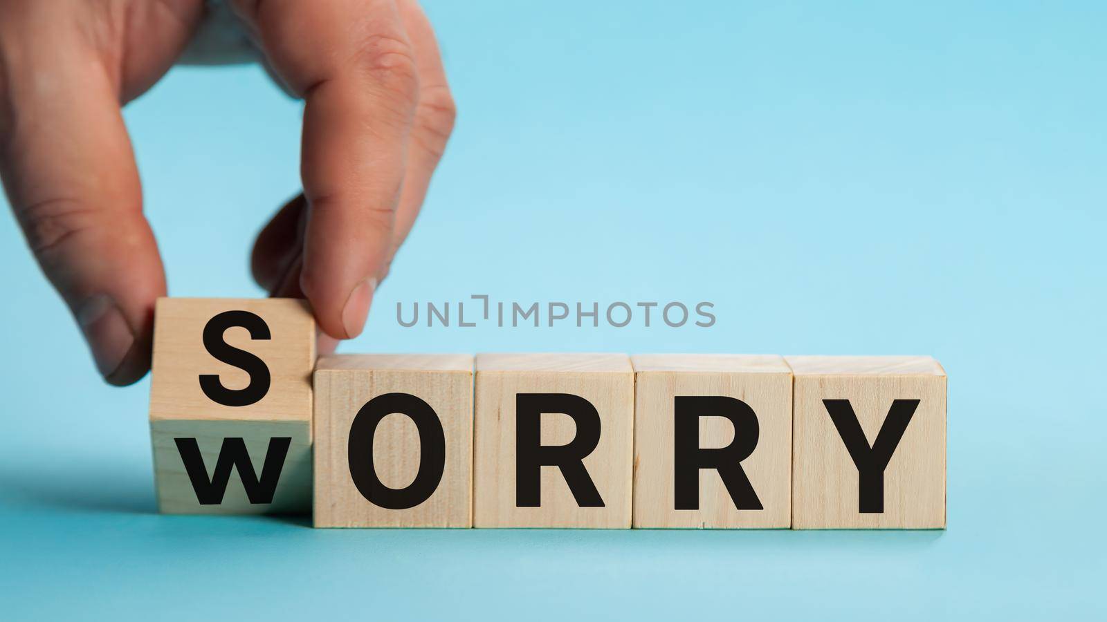 Sorry to worry. Hand turns a cube and changes the word worry to sorry. Business concept, copy space
