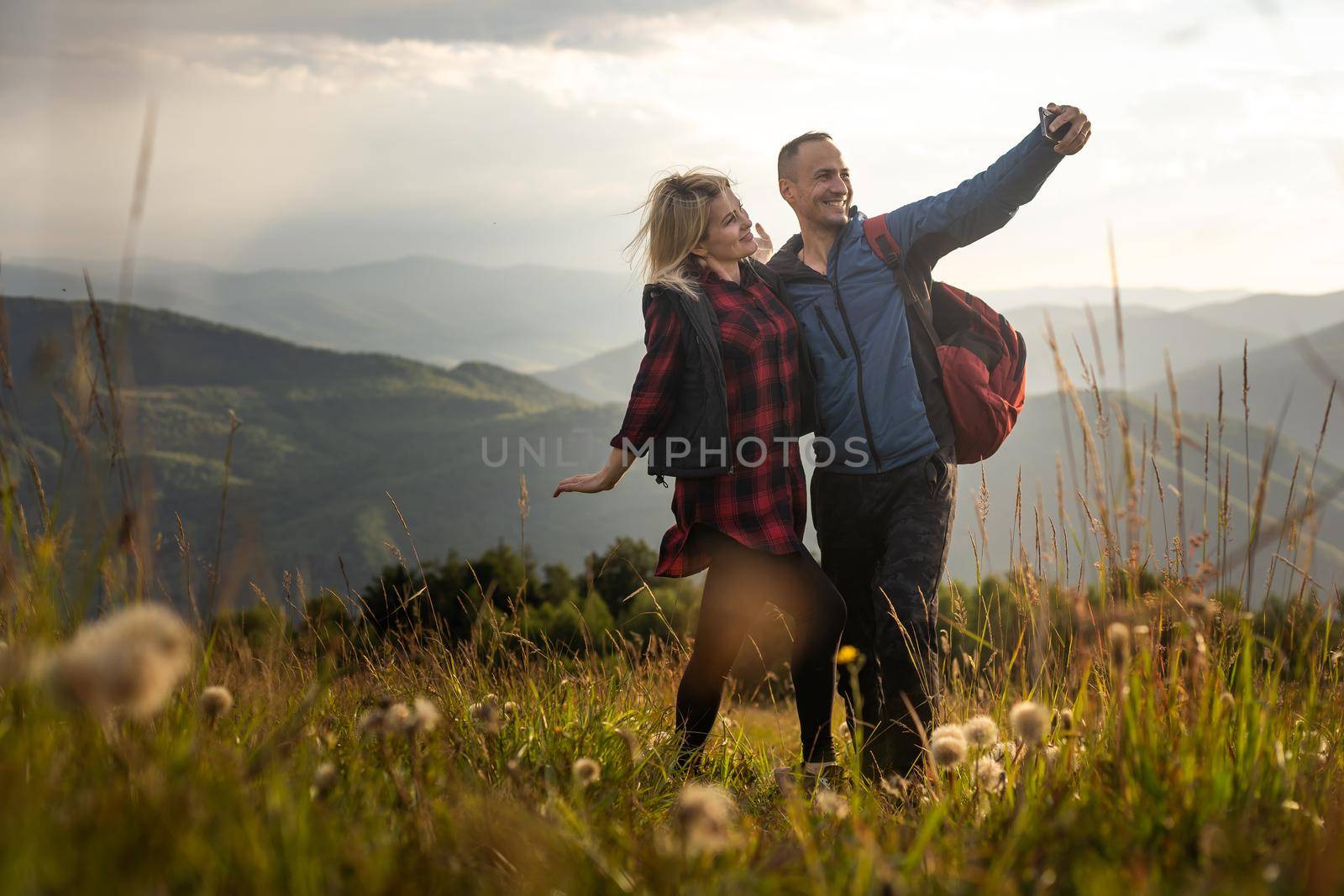Two hikers relax on top of a mountain with great view