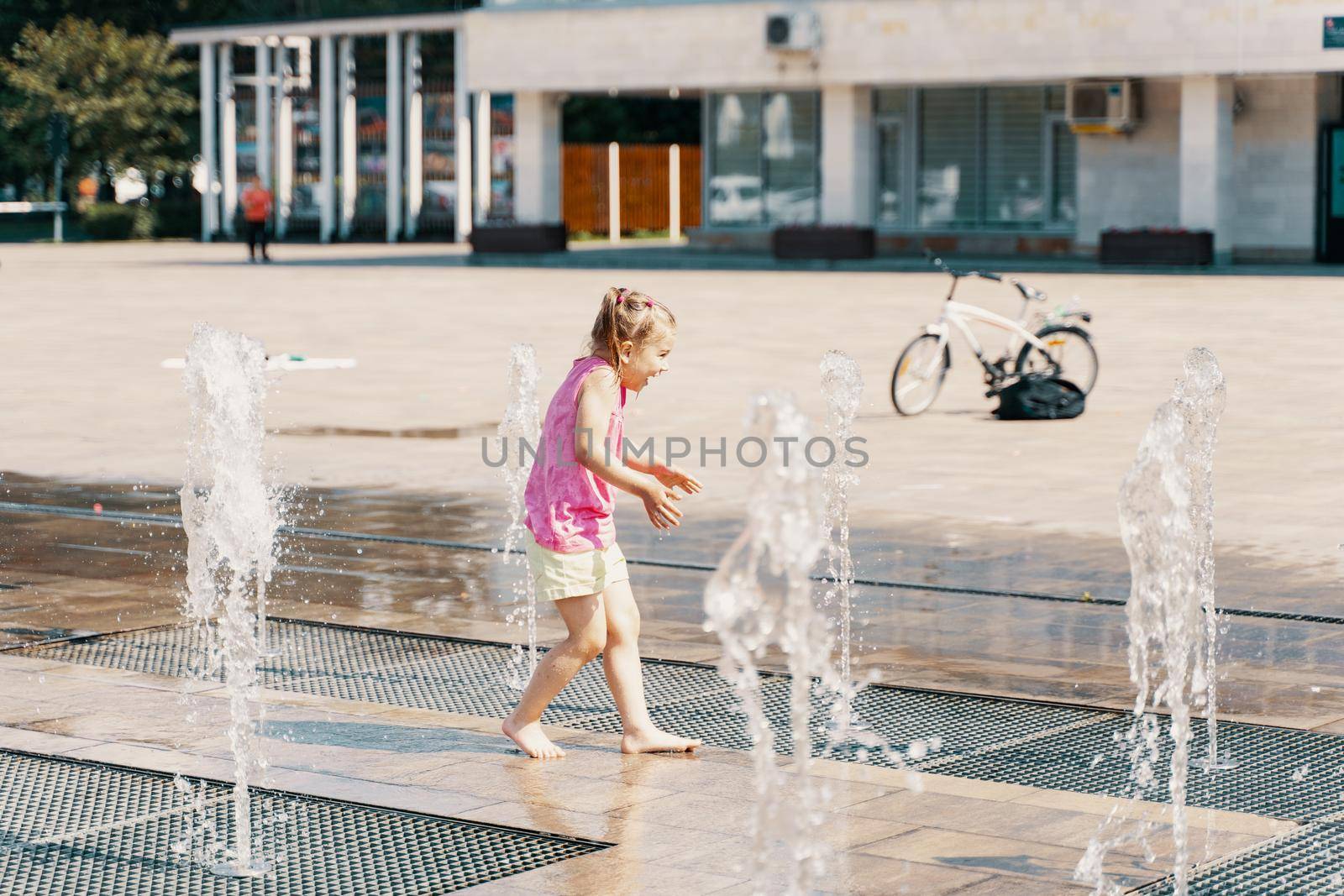 Happy kid playing in a fountain with water by Lena_Ogurtsova