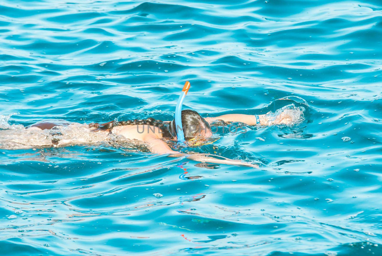 young girl is enjoying diving in the blue sea. High quality photo