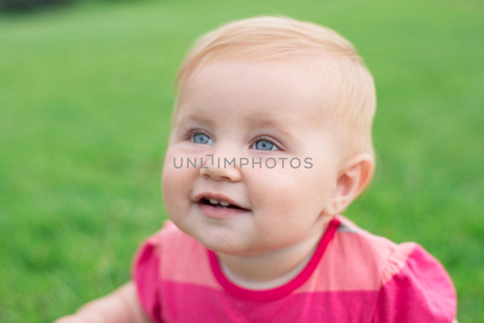 portrait of cute baby on a green lawn