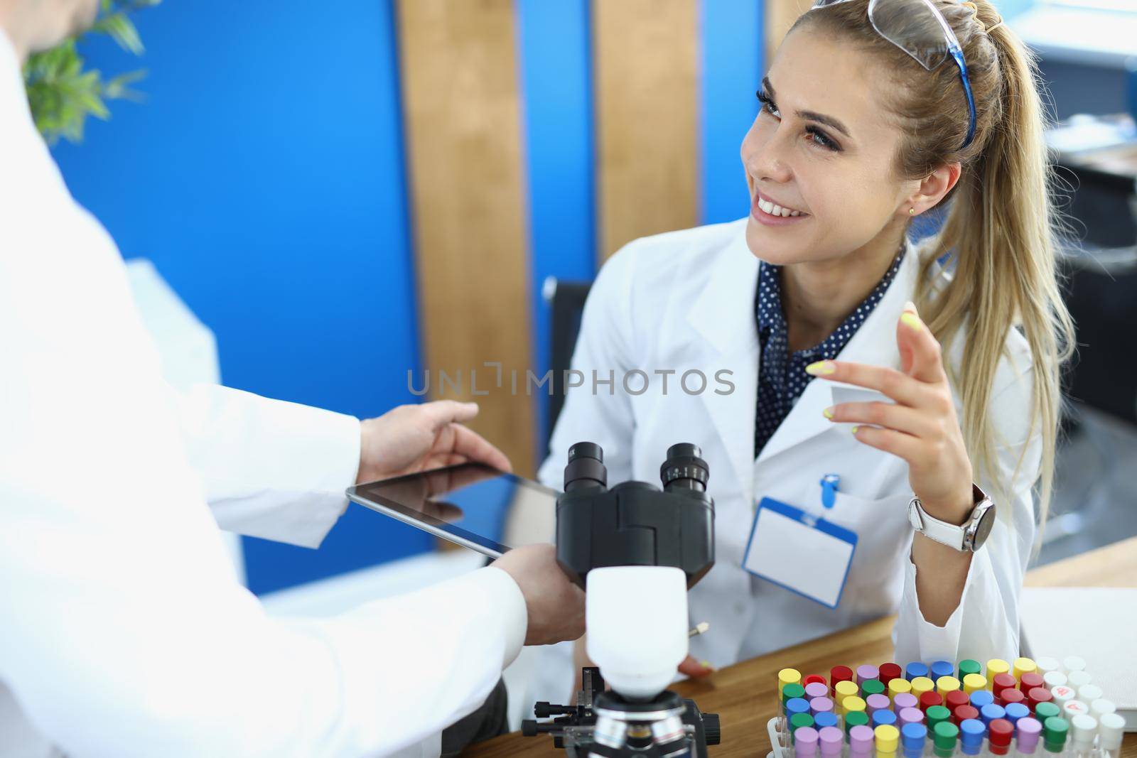 Physician scientists colleagues smile and communicate in laboratory. Learning and scientific experiments concept