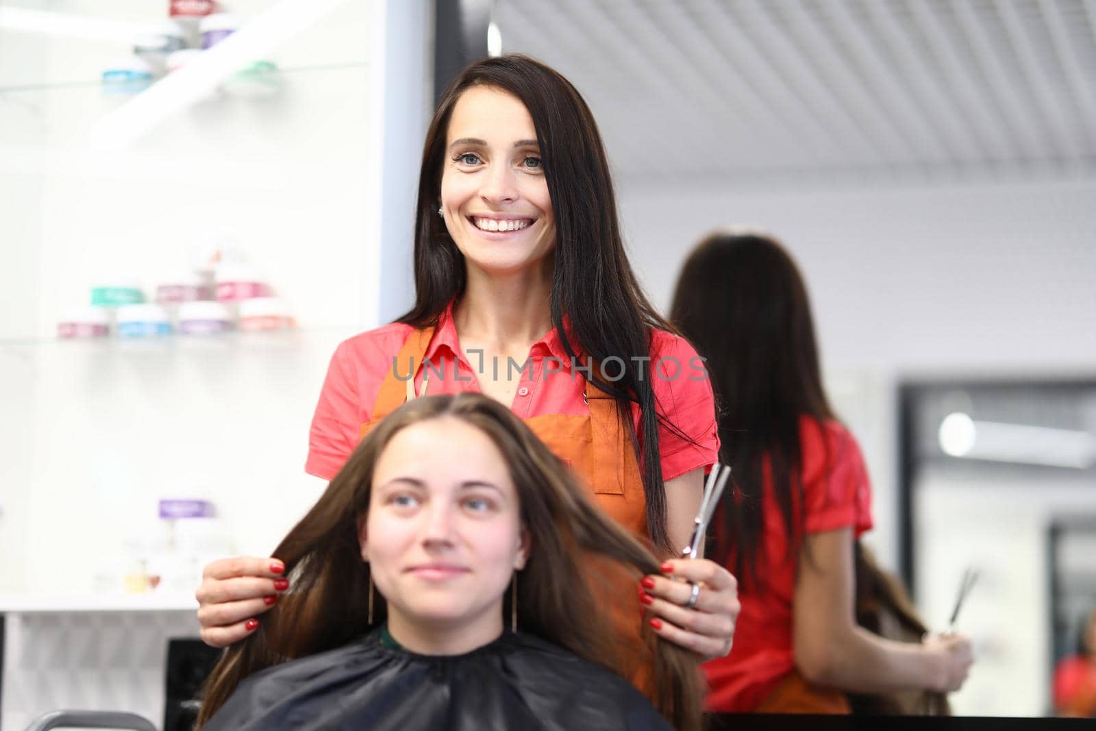 Professional hairdresser cuts female hair in salon. Beauty salon services and trendy haircuts concept