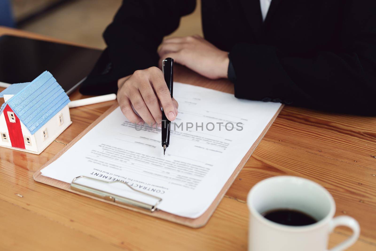 Asian female bank employee asking a customer to read the contract before signing to agree to buy a house, real estate concepts.