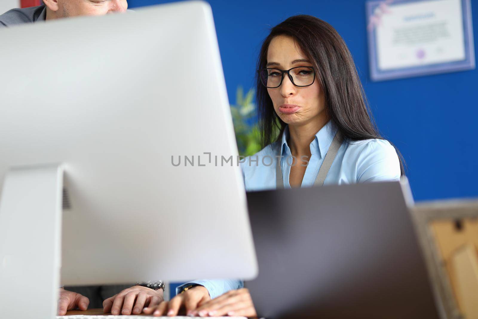 Offended woman works on computer in office. Emotions and business mistake concept