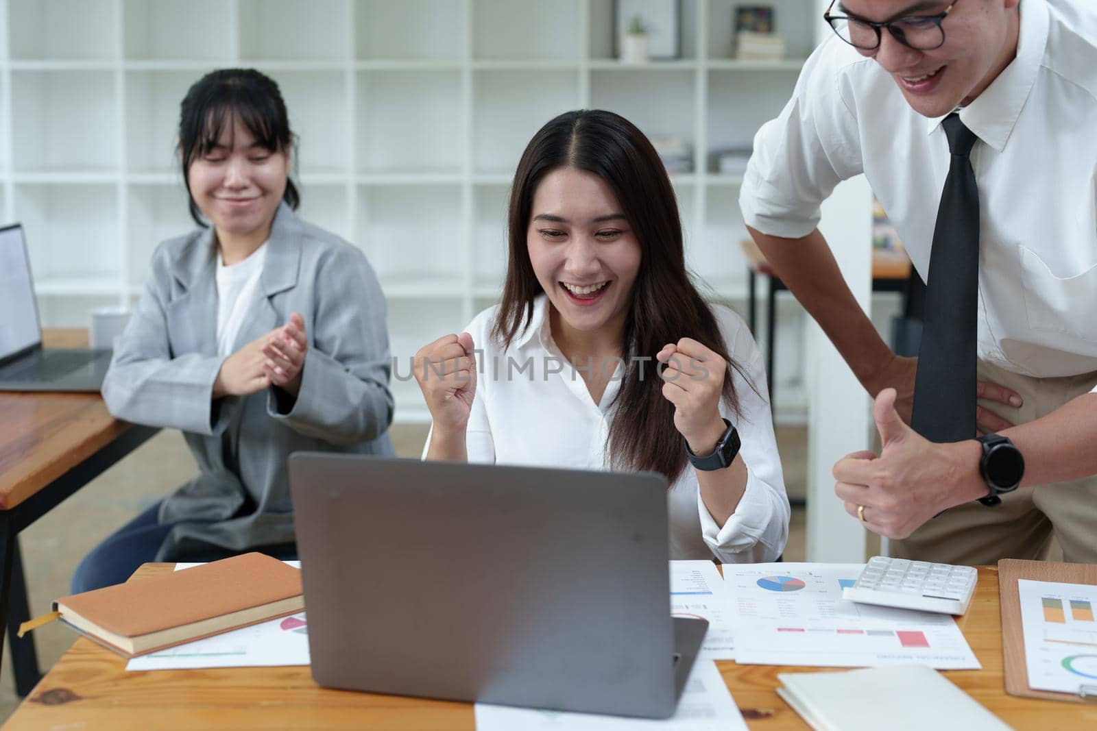 A portrait of three Asian business showing joy from sales of new projects that meet customer demand by Manastrong