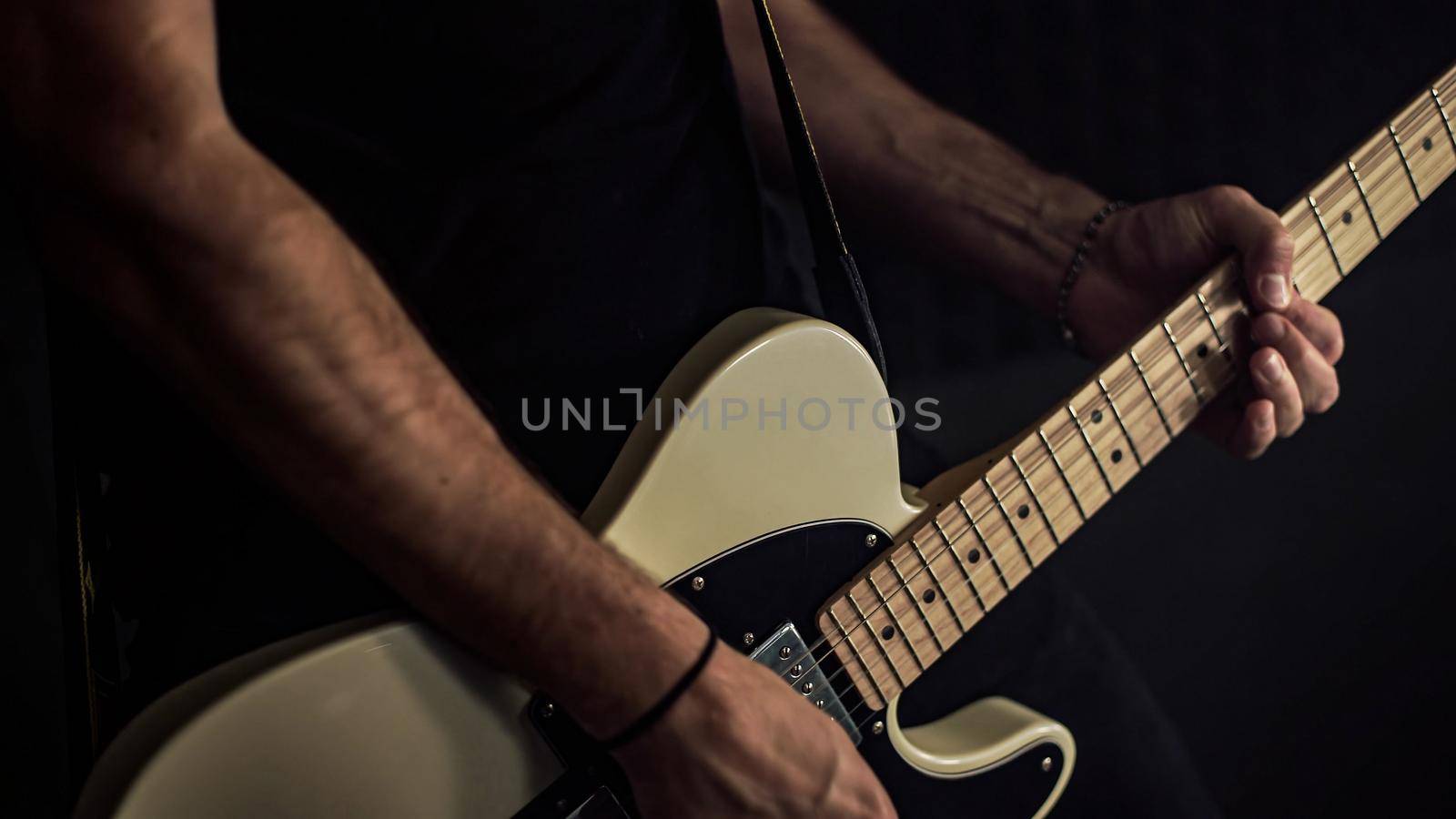 Young professional guitarist plays an acoustic guitar details by pippocarlot