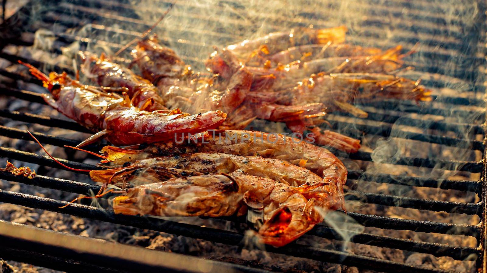 Grilled shrimp on a grill with charcoal grill. Close-up of shrimps being fried in oil pan