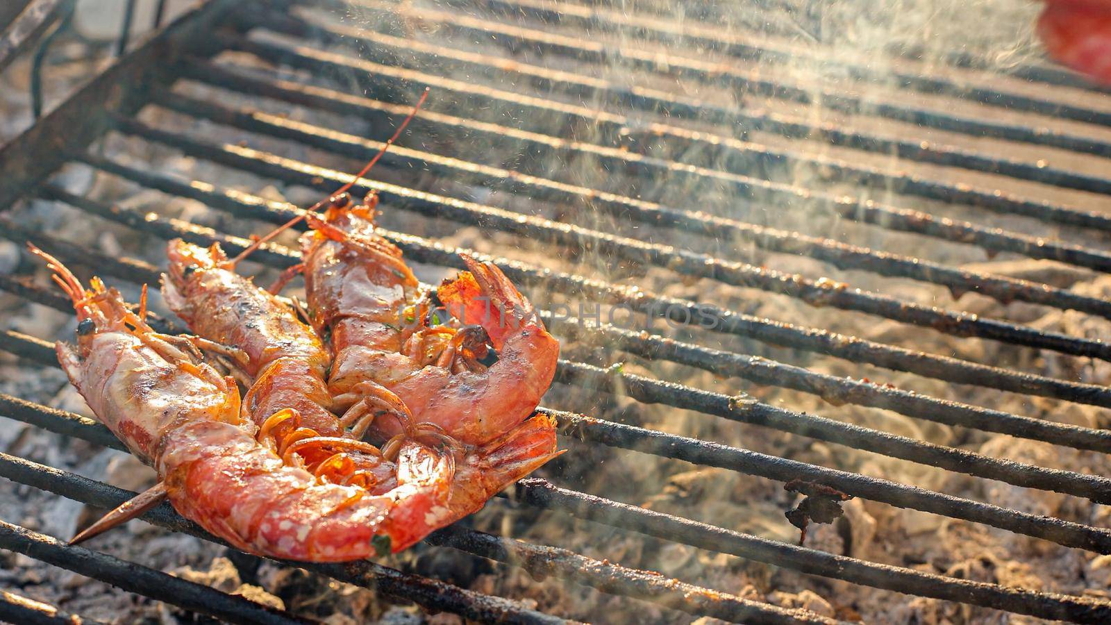 Grilled shrimp (Giant freshwater prawn) grilling with charcoal. Grilled shrimp on a grill with charcoal grill. Close-up of shrimps being fried in oil pan