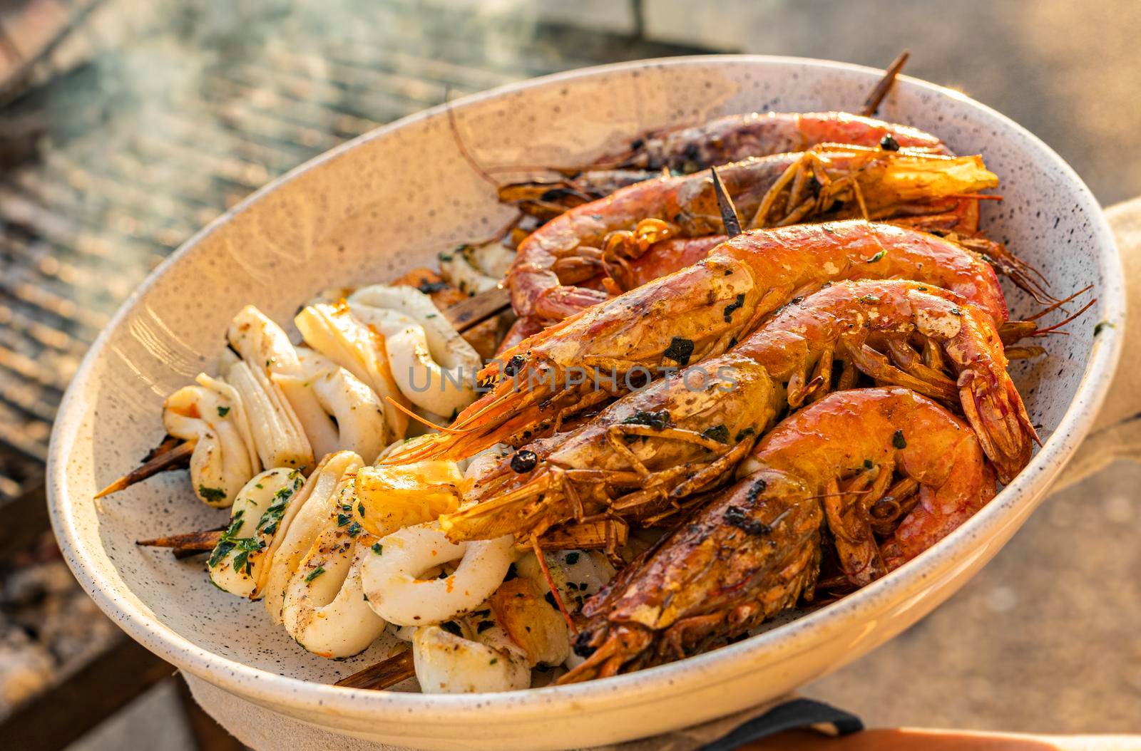 Plate of shrimp and grilled fish close up shot