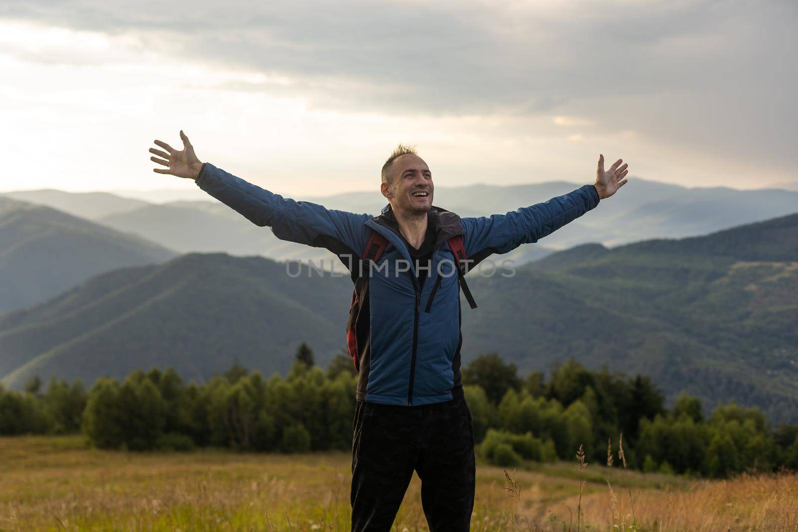 Young man enjoying the view on the top of the mountain. Carpathian mountains, Ukraine.