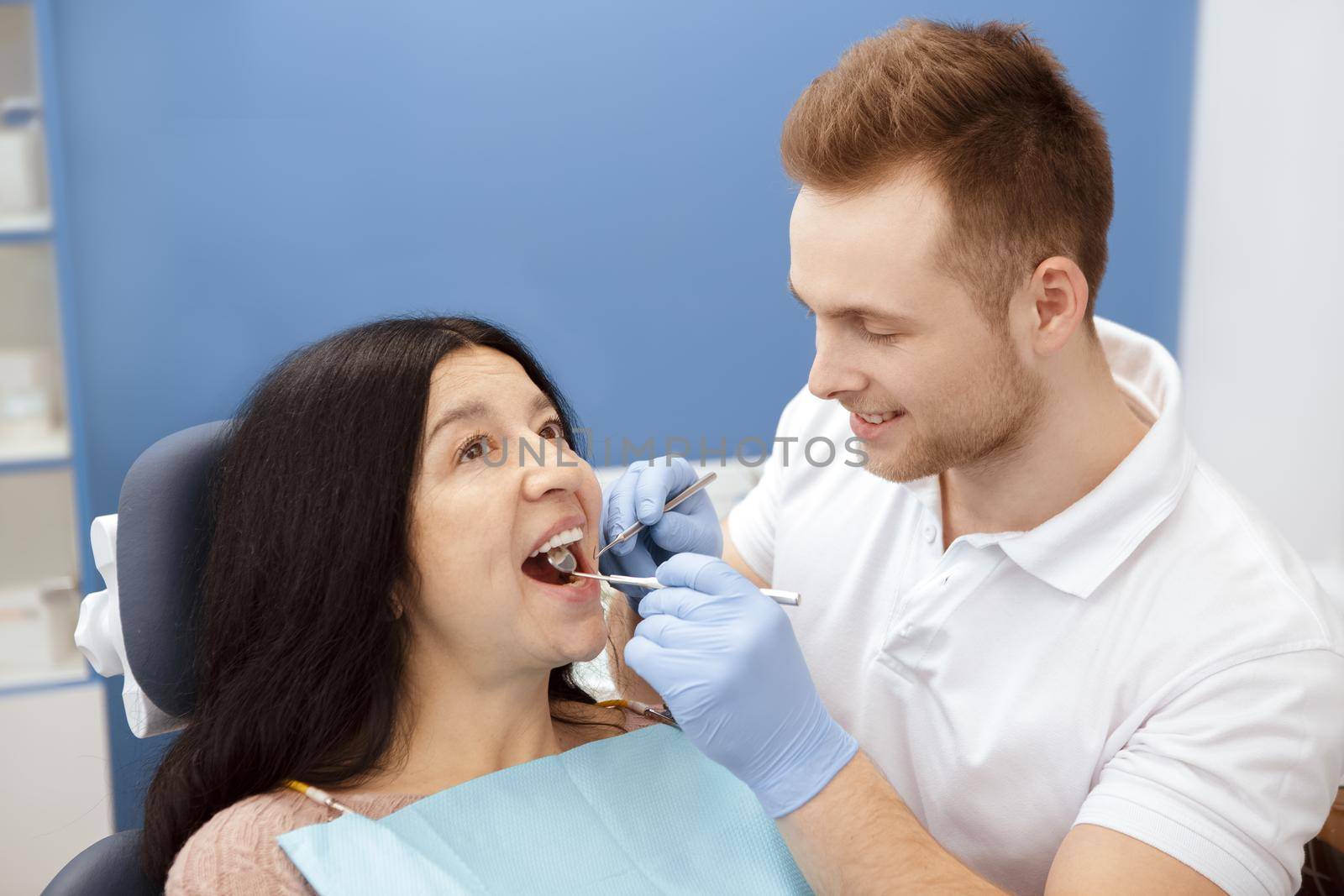 On the way to healthy. Young professional male dentist examining teeth of his senior female patient health medicine clinical insurance procedure dentistry dental checkup profession job professionalism