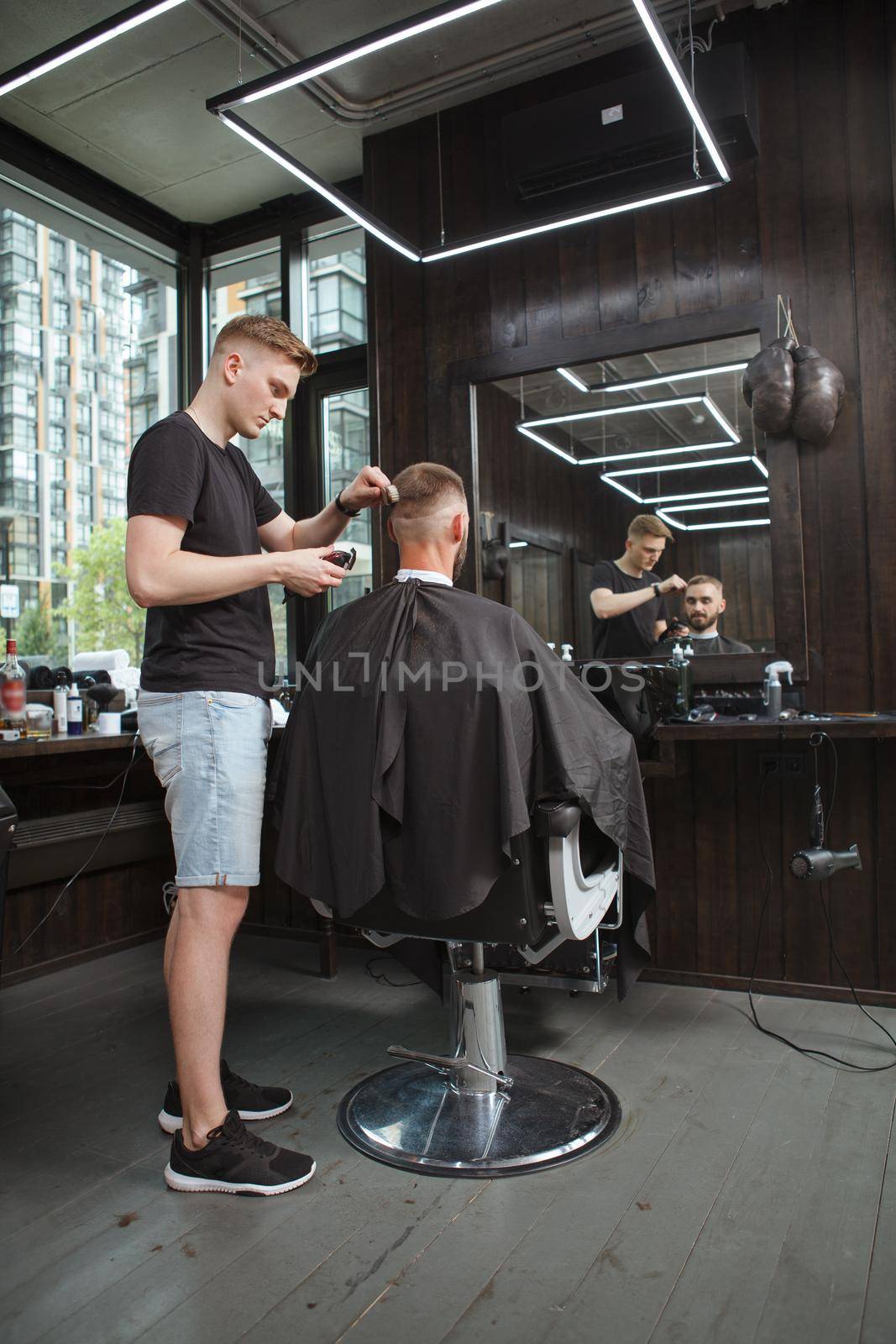 Vertical full length shot of a professional barber working at his barbershop