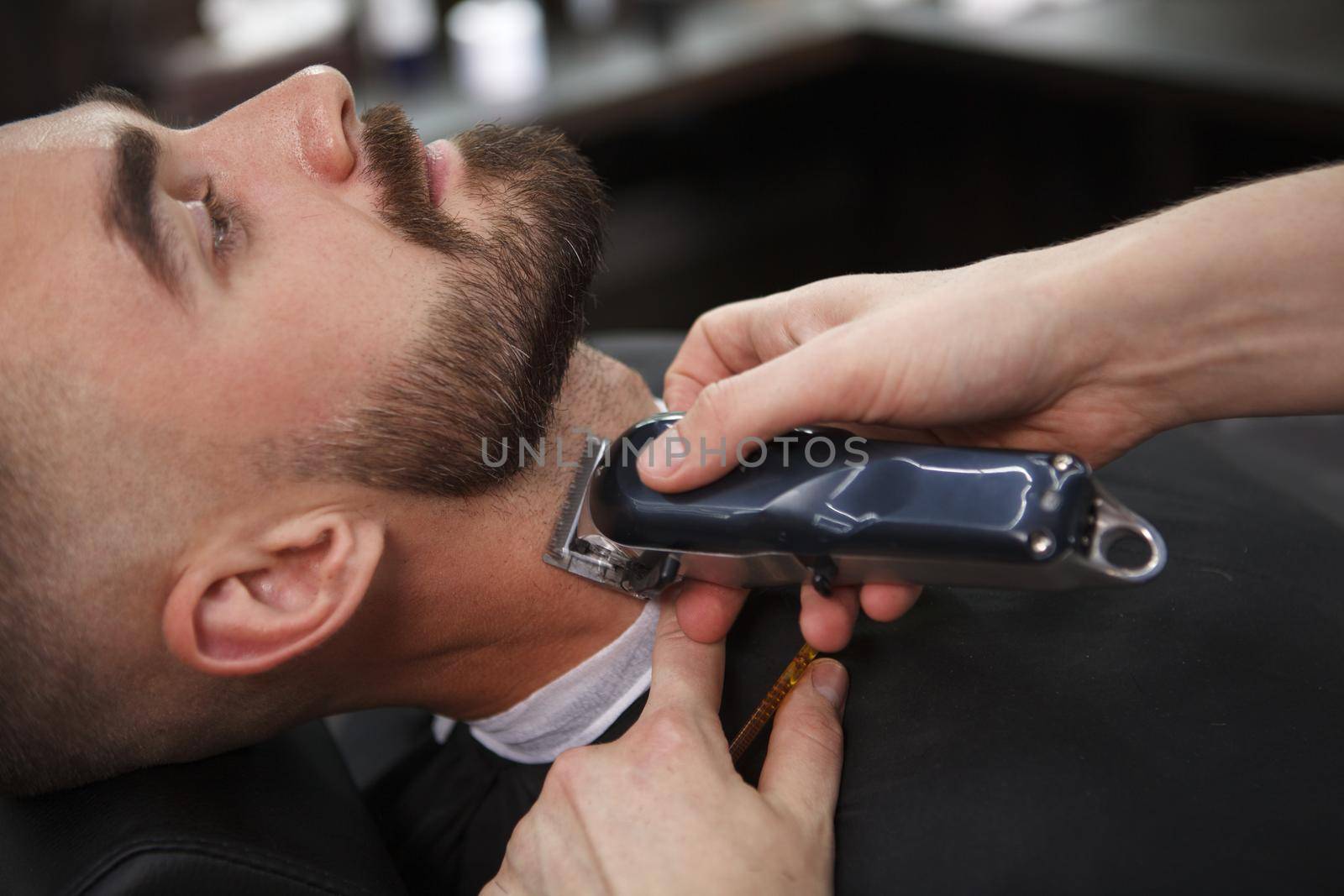 Man getting beard cut by professional barber by MAD_Production