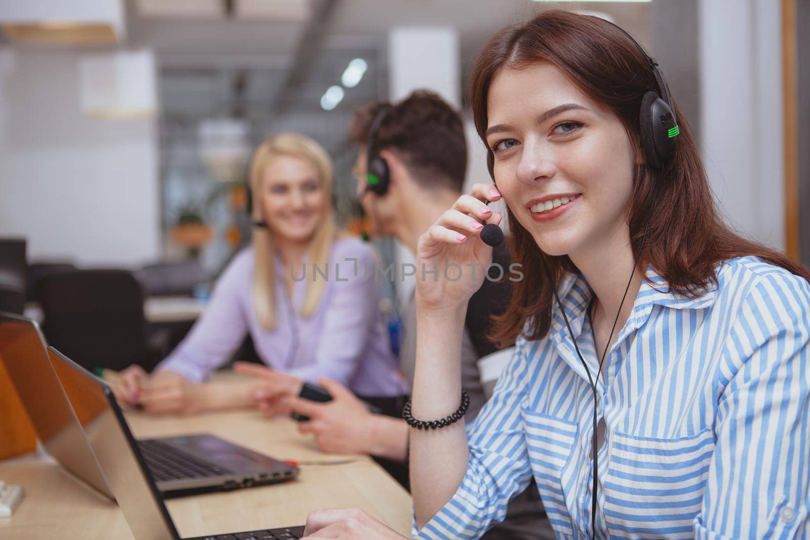 Cheerful call center operator at work by MAD_Production
