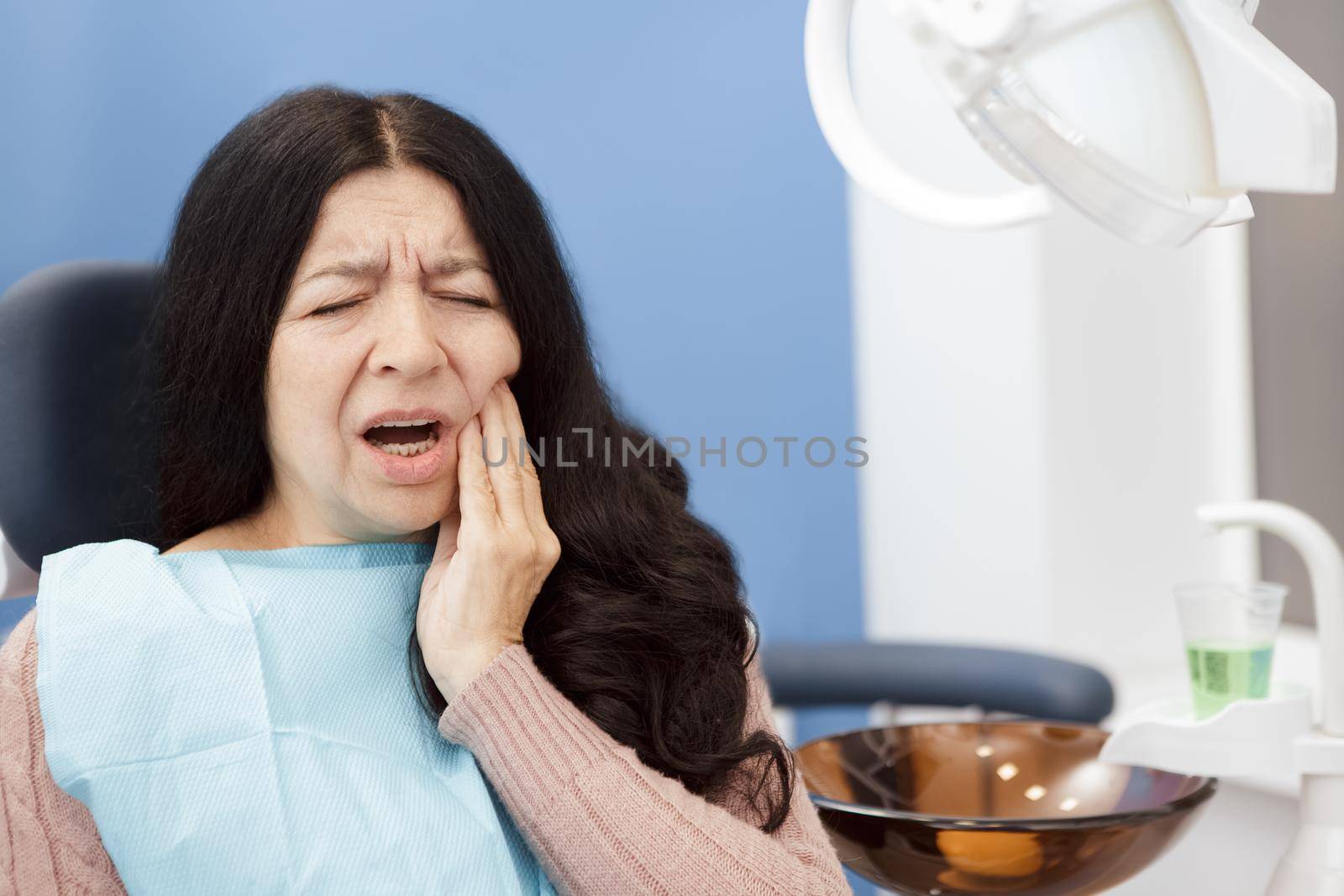Senior woman suffering from toothache by MAD_Production