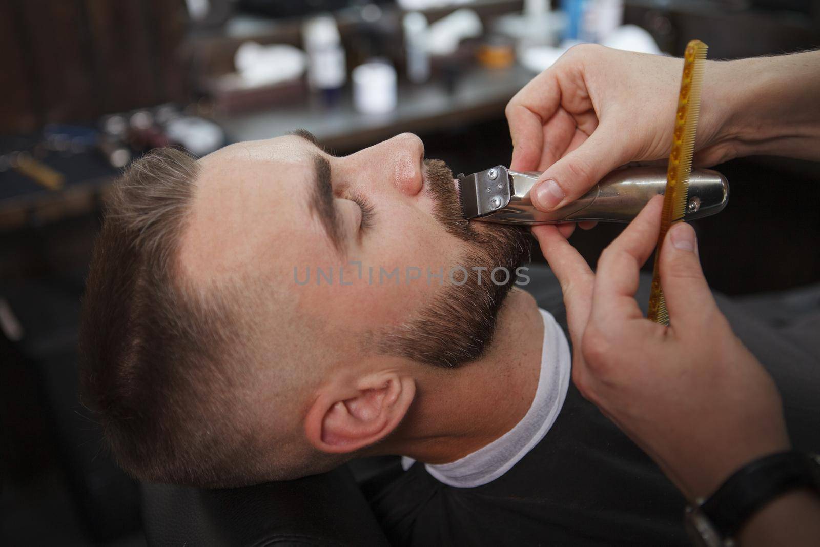 Man getting beard cut by professional barber by MAD_Production