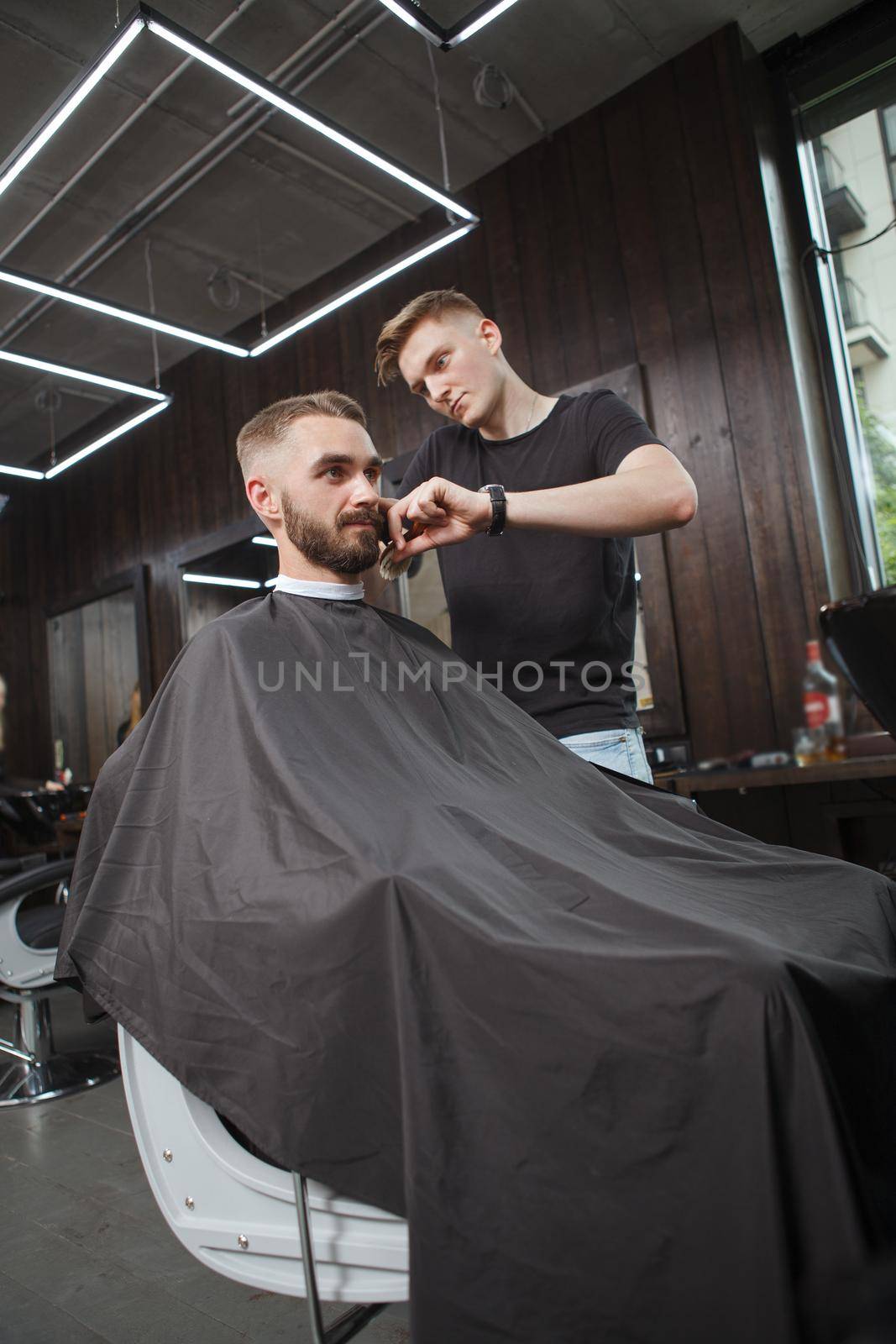 Bearded man getting new haircut at barbershop by MAD_Production