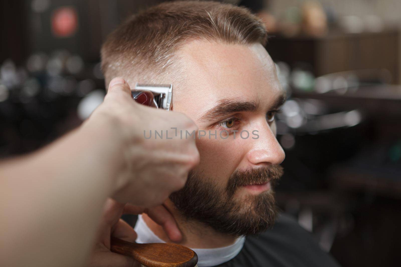 Bearded man getting new haircut at barbershop by MAD_Production