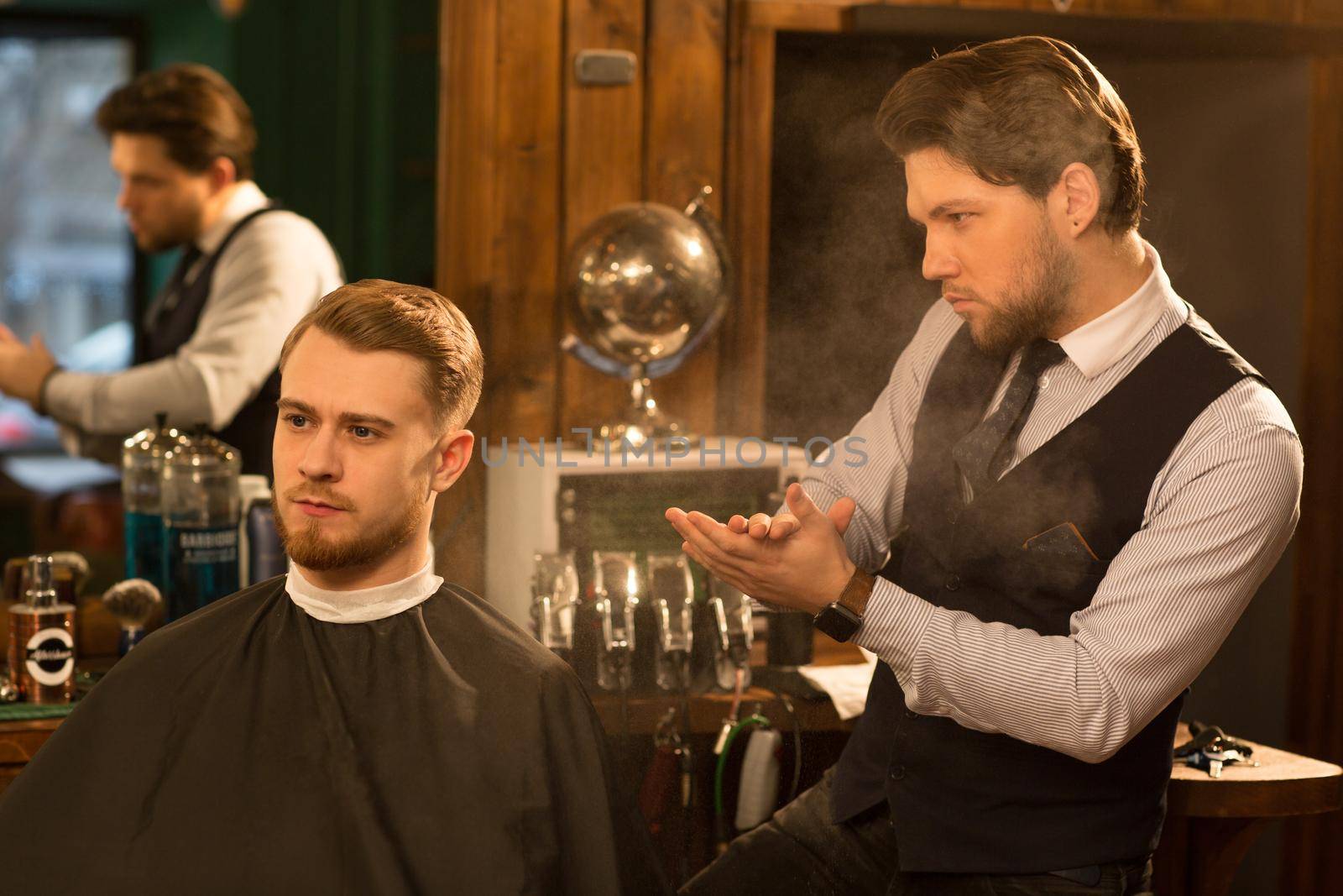 Shot of a handsome professional barber powdering his hands examining new haircut of his client after cutting his hair copyspace service people lifestyle hipster vintage classic traditional styling.