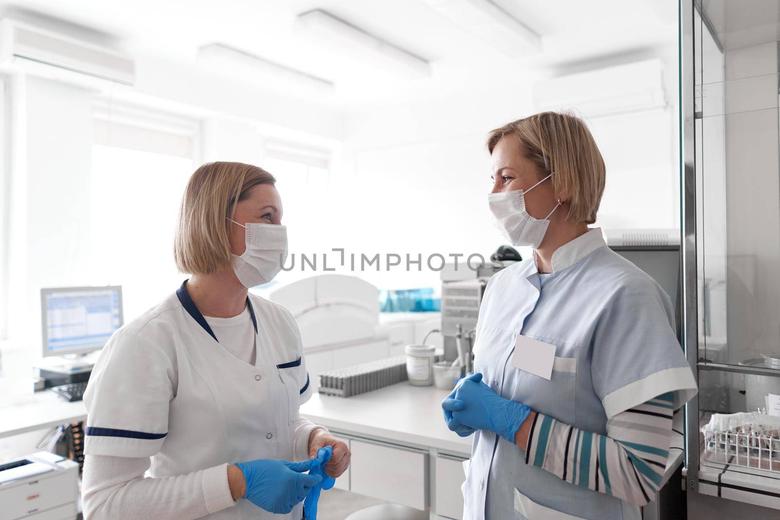 Two female doctors with facial mask chatting in a hospital