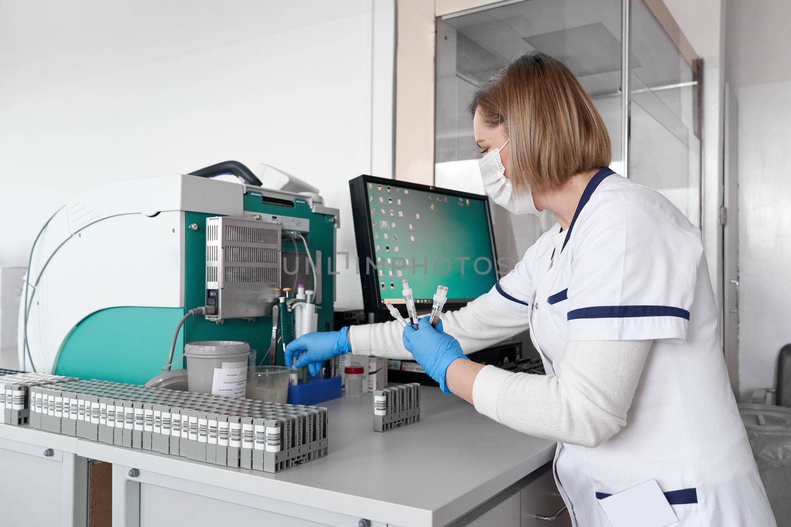 Hospital laboratory technician arranging samples in a centrifuge reaction vessel